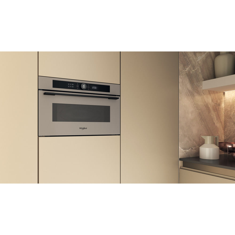 Un forno a microonde da incasso installato in un mobile da cucina. Ha una finitura in acciaio inossidabile.