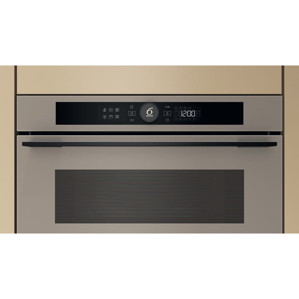 Primo piano di un forno a microonde da incasso, con display digitale e pulsanti di controllo, in un mobile da cucina.