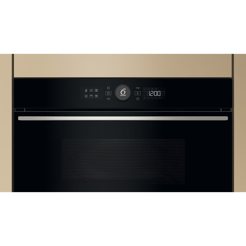 Un primo piano di un moderno forno a microonde integrato in un mobile da cucina.