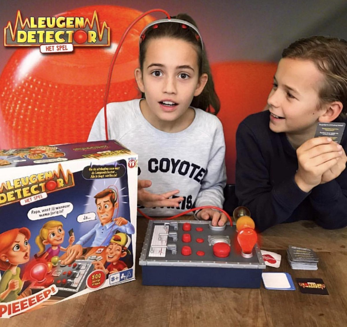 Un juego de mesa con dos niños jugando y un detector de mentiras.