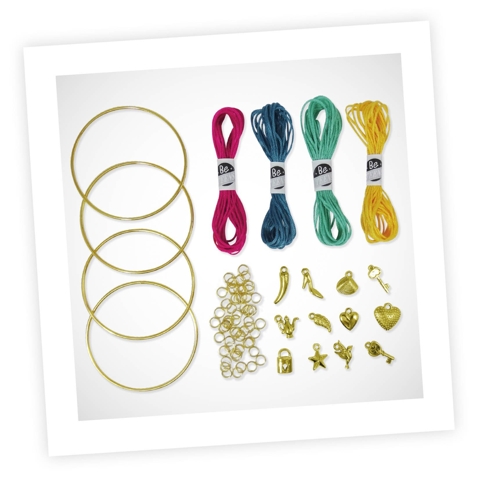 Cztery złote obręcze, kolorowe nici i zawieszki na białej powierzchni.