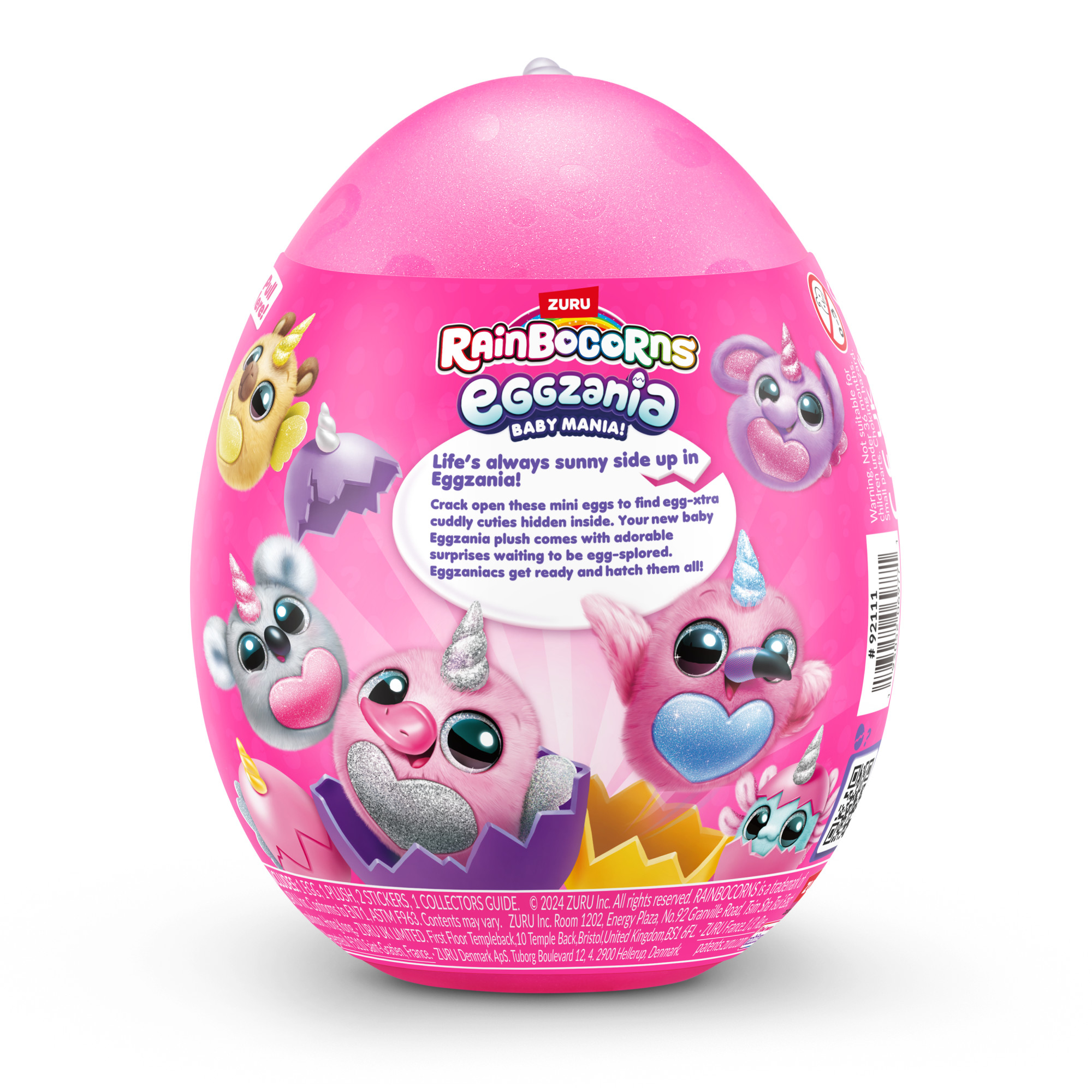 Różowe opakowanie zabawki w kształcie jajka z kreskówkowymi obrazkami jednorożców. Produkt z tekstem 'Rainbocorns Eggzania' i 'Baby Mania'.