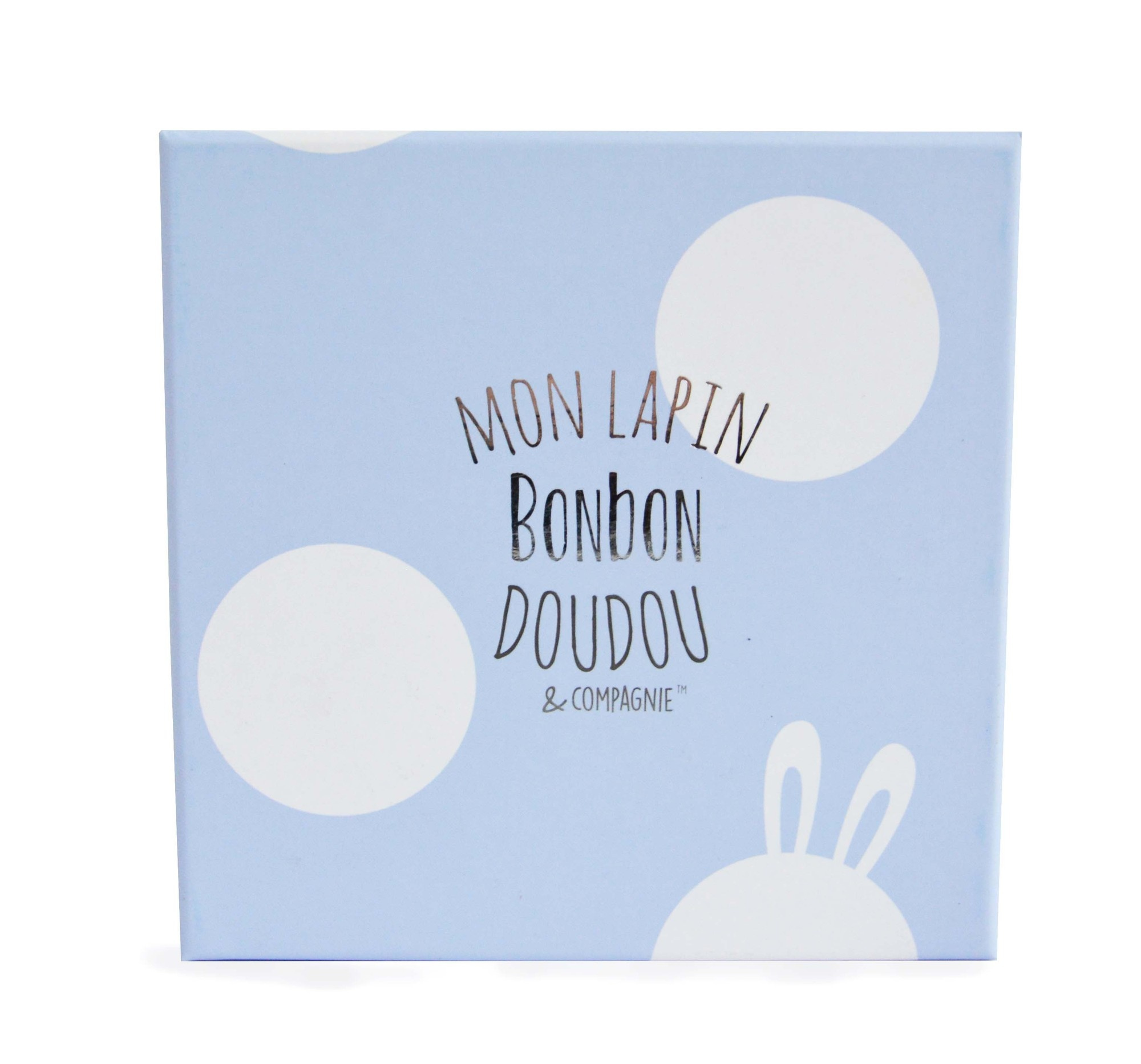 Niebieskie pudełko z białymi kropkami i francuskim tekstem: Mon Lapin Bonbon Doudou & Compagnie, uszy królika.
