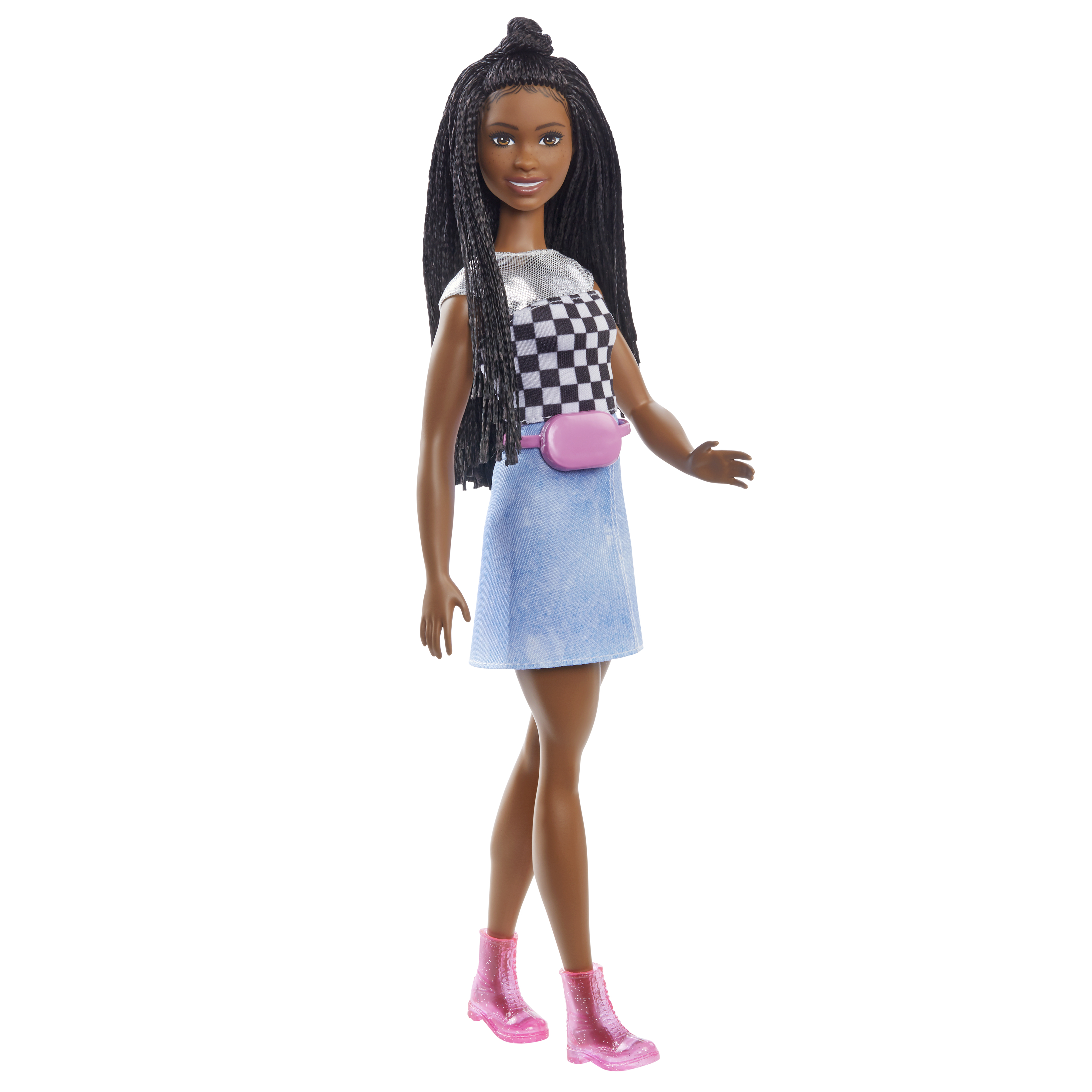 Eine schwarze Barbie-Puppe steht vor weißem Hintergrund, trägt kariertes Oberteil, Jeansrock und pinke Stiefel.