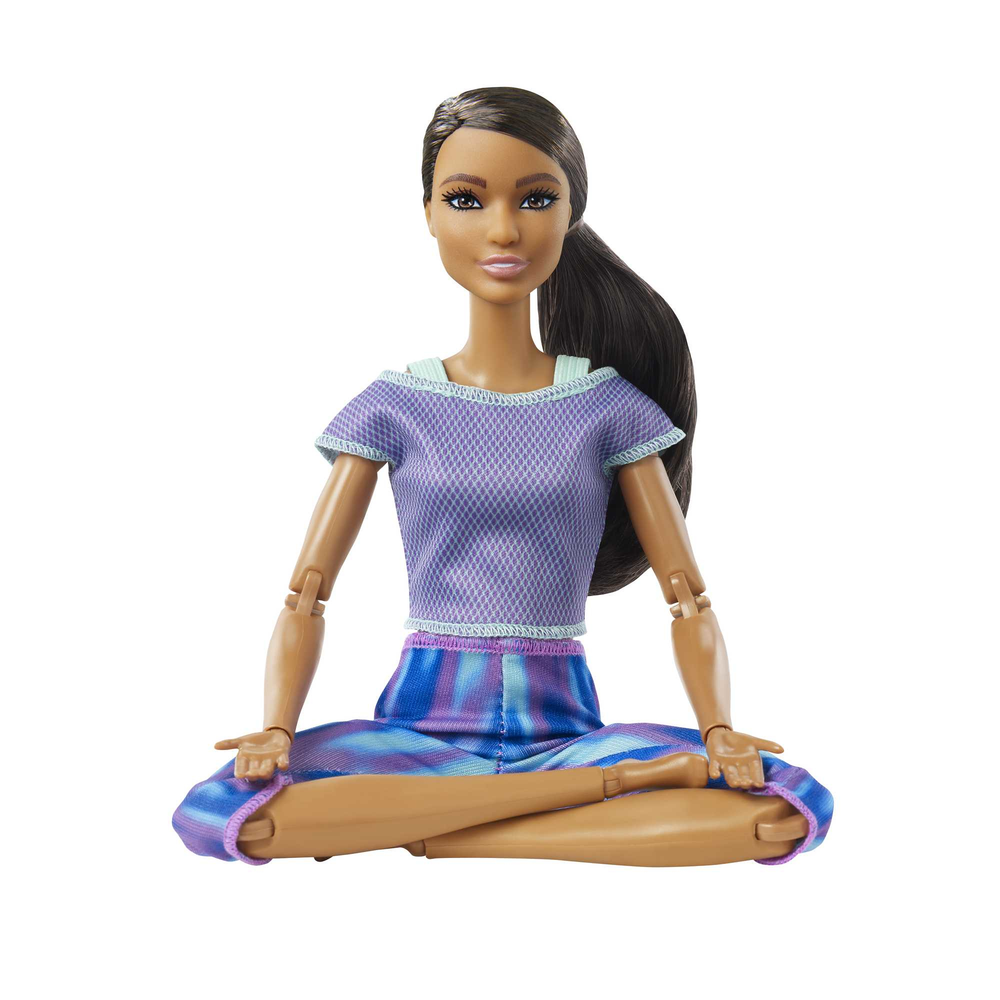 Barbie-Puppe in Yoga-Pose, sitzt im Schneidersitz, trägt ein lila Oberteil und blaue Leggings.