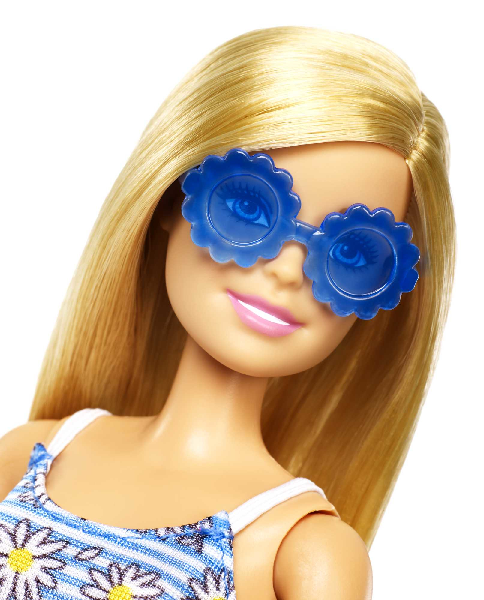 Blonde Barbie-Puppe mit blauen blütenförmigen Sonnenbrillen, blickt in die Kamera.