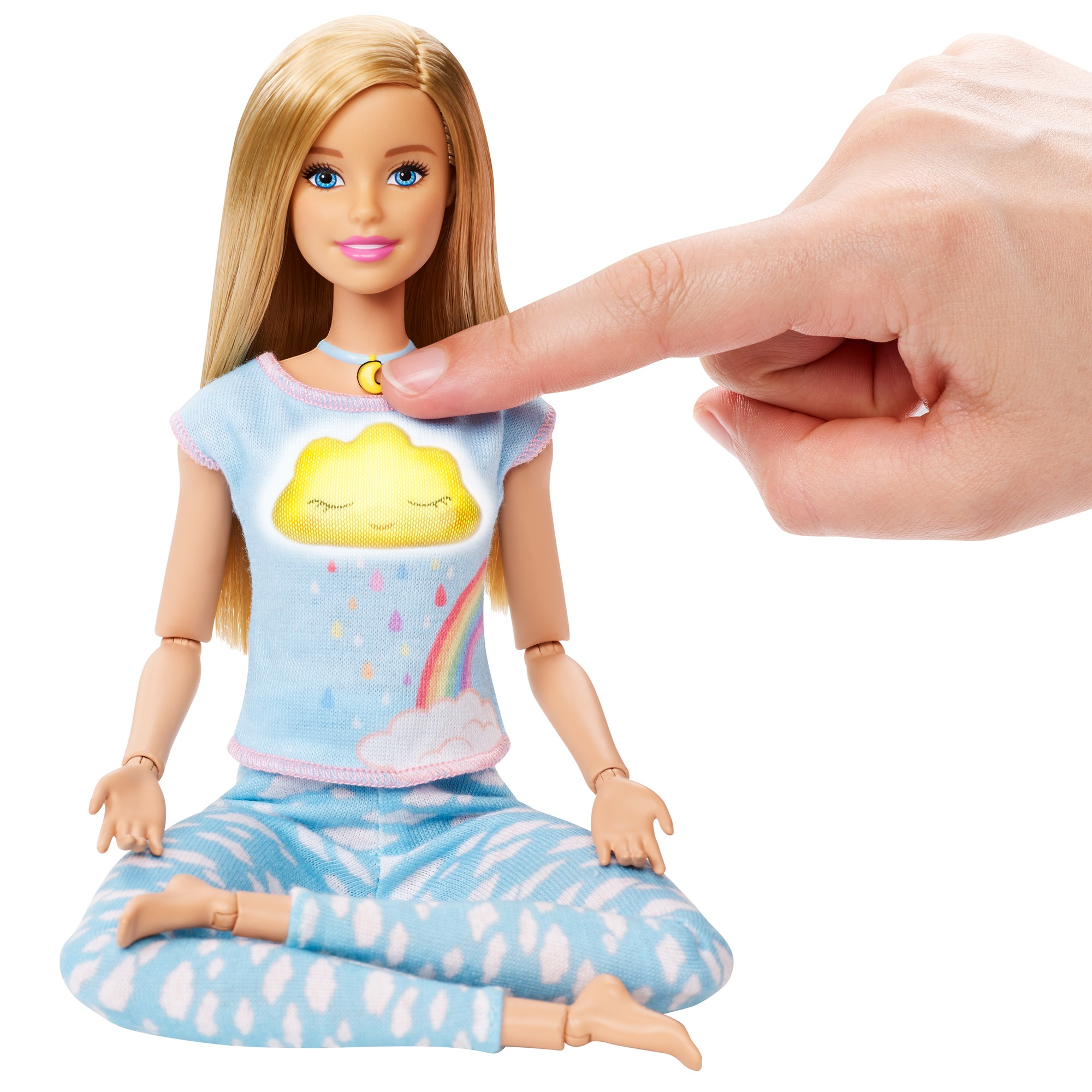 Eine Barbie-Puppe in sitzender Position, ein Finger zeigt auf das Wolkensymbol auf ihrem Hemd.