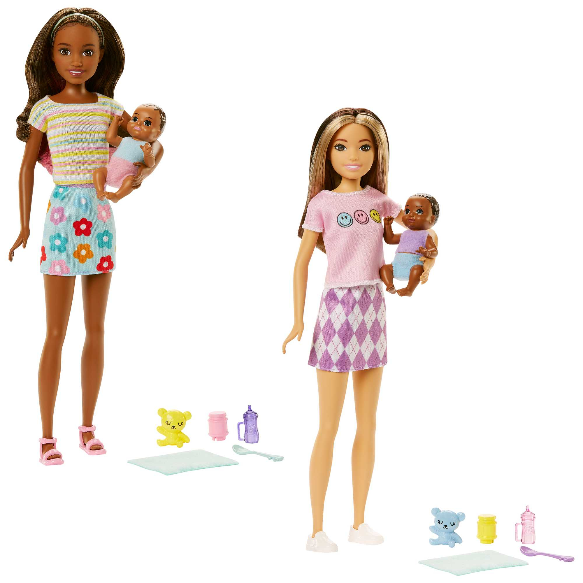 Due bambole Barbie che tengono bambolotti, con accessori come biberon e giocattoli, su sfondo bianco.