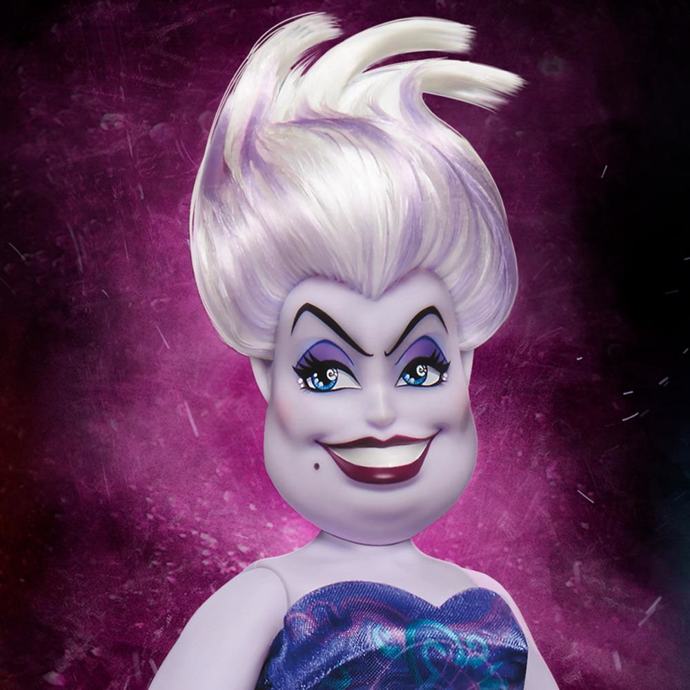 Ursula-Puppe mit weißen Haaren und lila Haut. Sie trägt ein lila Kleid und hat ein finsteres Lächeln. Lila Hintergrund.