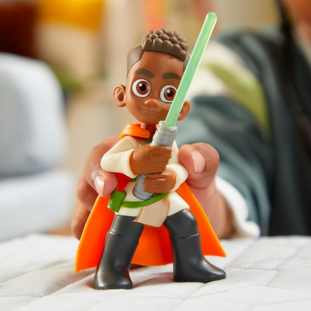 Personaggio dei cartoni animati di Star Wars di un ragazzino con una spada laser verde. Indossa un mantello arancione. Sfondo sfocato.