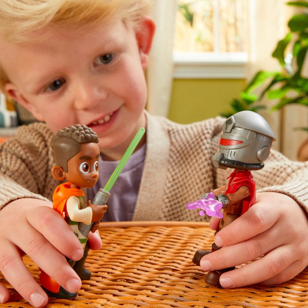 Un bambino gioca con i giocattoli di Star Wars. Una figura ha una spada laser verde. L'altra ha un elmo rosso.