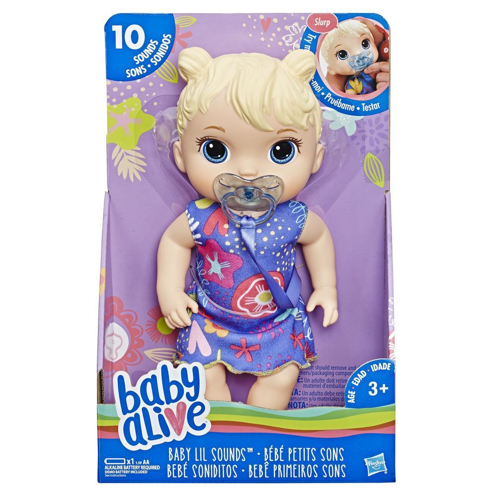 Eine Baby Alive Puppe in einem blauen Kleid mit Schnuller, in einer Box.
