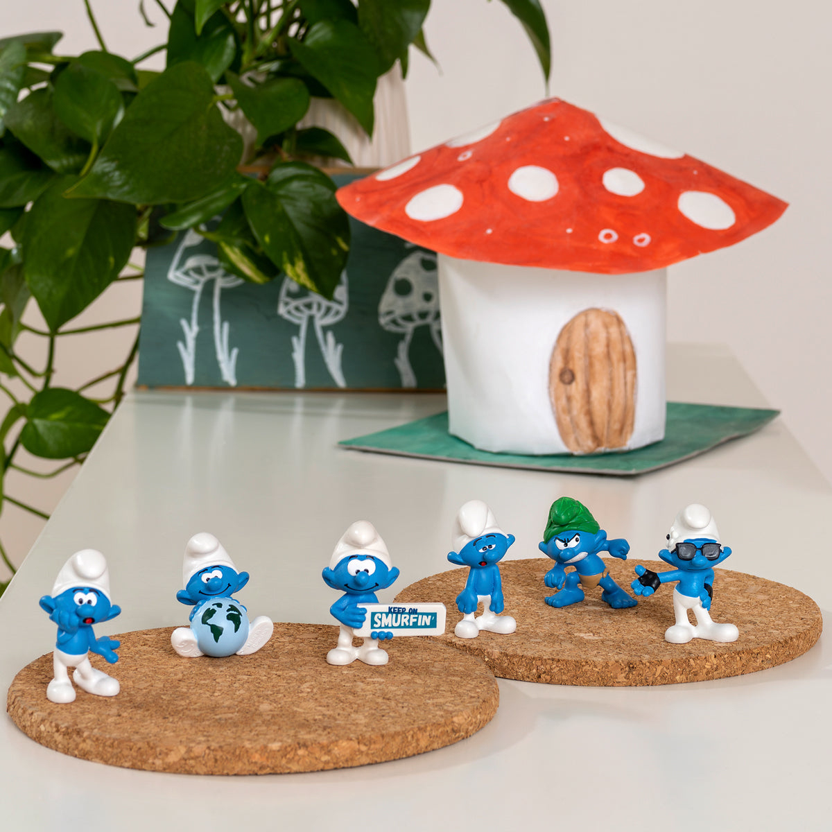 Un bambino guarda i Puffi su sughero. Una casa a forma di fungo e piante sullo sfondo.