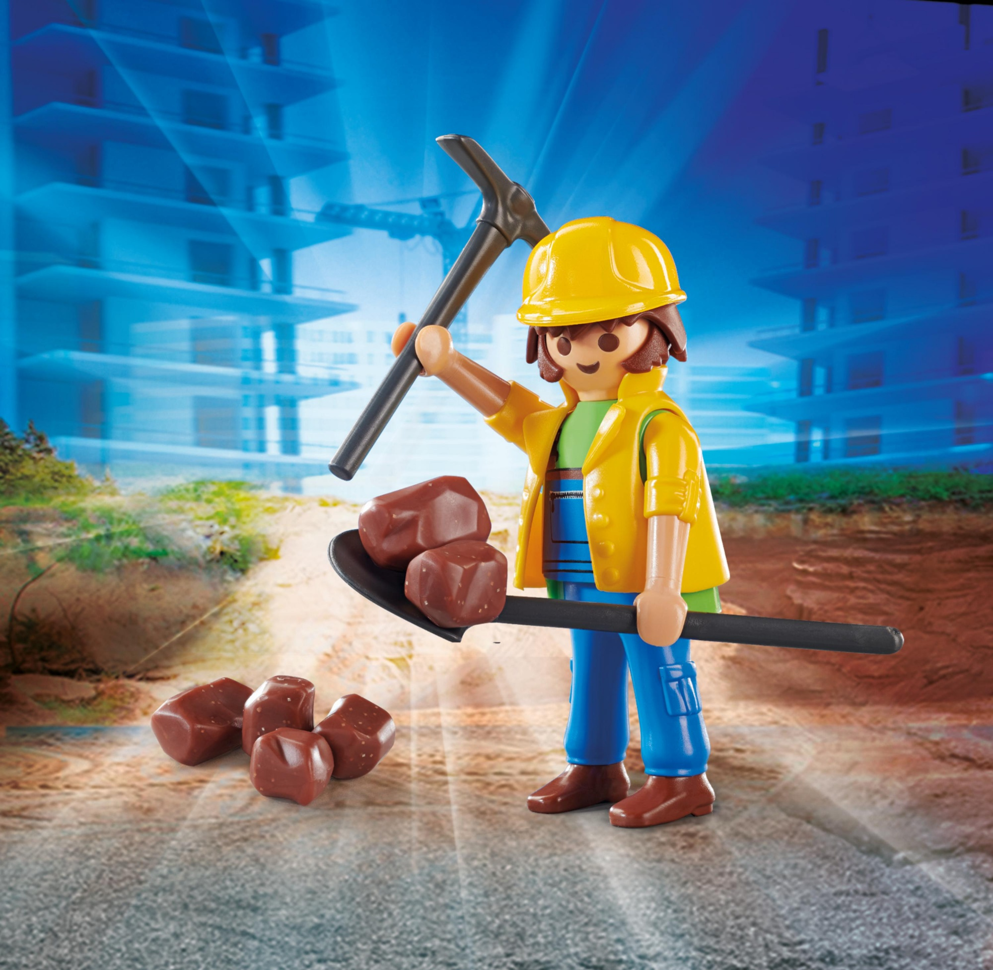 Zabawka robotnika budowlanego z kilofem i łopatą trzymającym brązowe kamienie. Żółty kask i niebieski kombinezon.