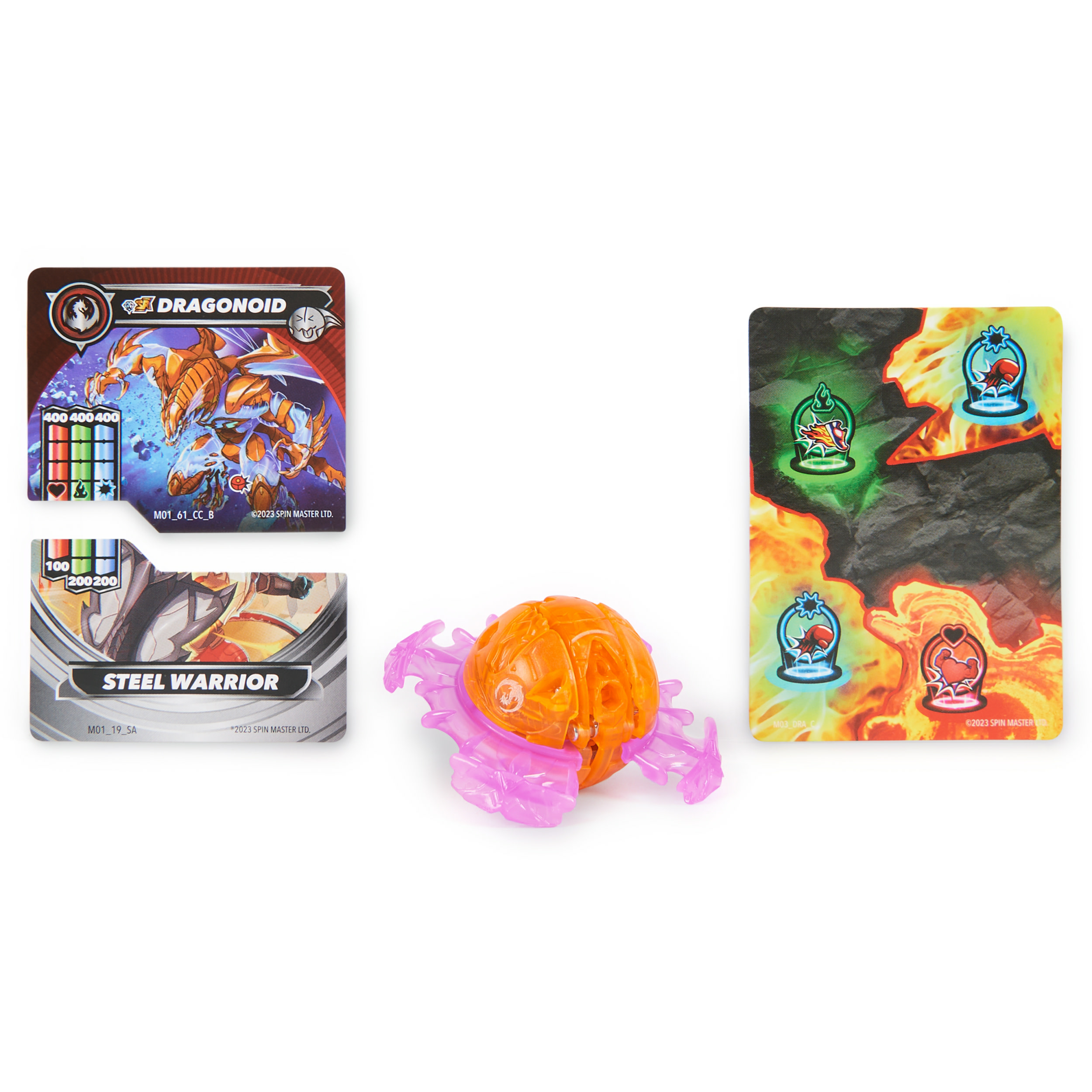 Karty i zabawki Bakugan. Pomarańczowa i różowa kula Bakugan, otoczona kartami. Białe tło.