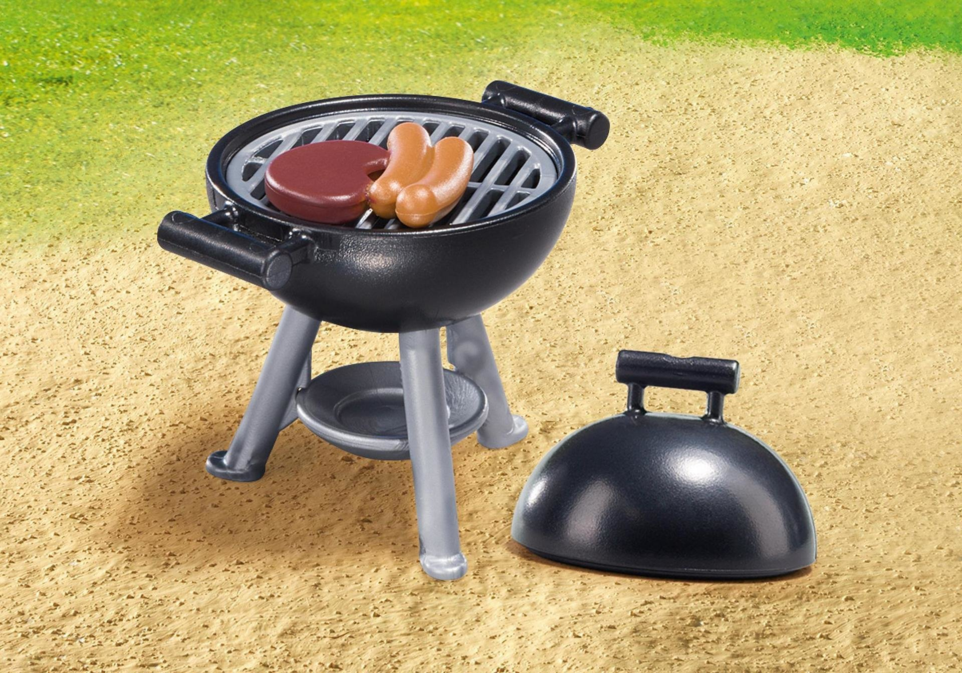 Ein Miniatur-Schwarzgrill mit Steak und Würstchen auf grün-beigem Hintergrund.
