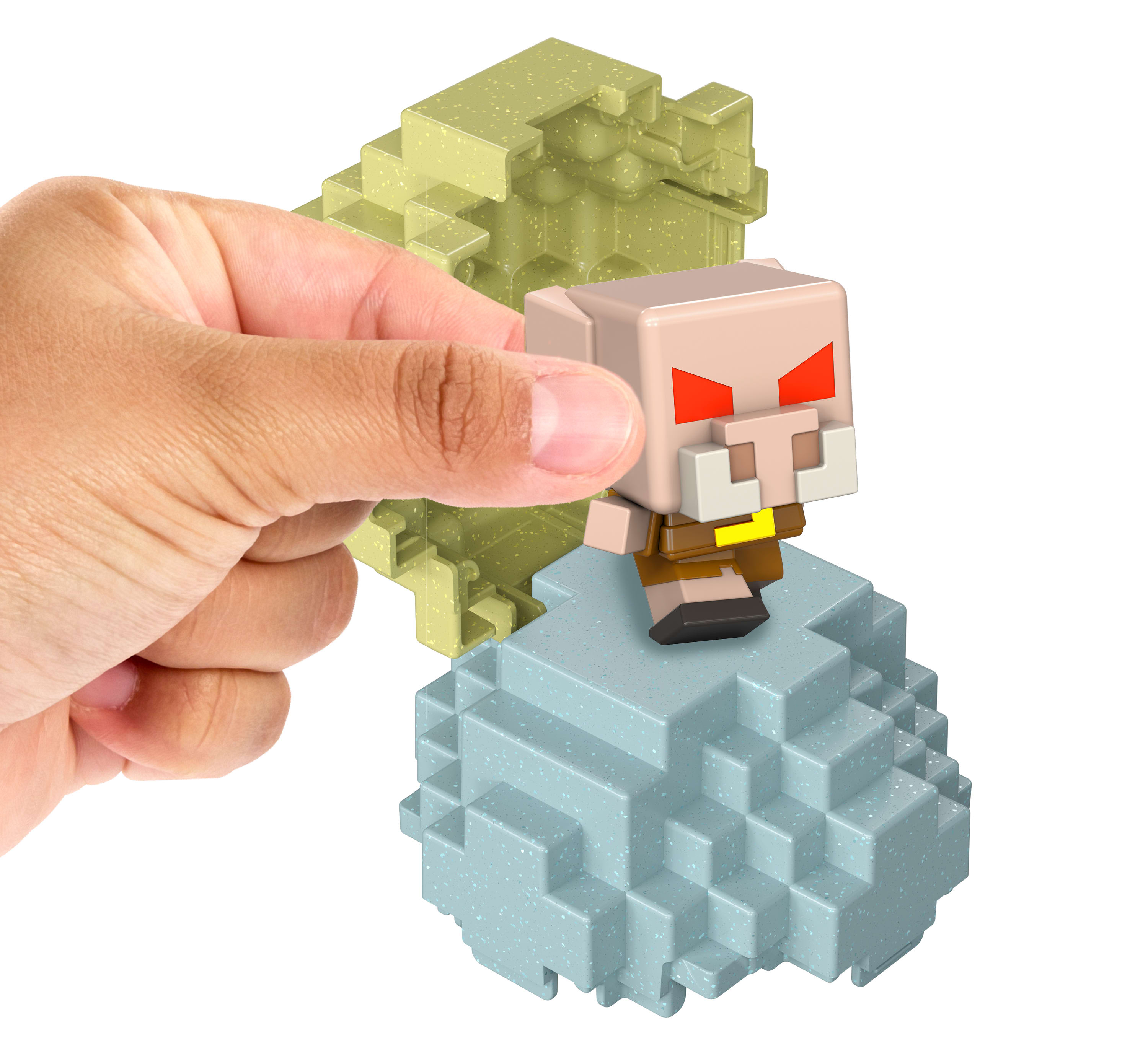 Ręka trzyma figurkę Minecraft przypominającą świnię na blokowej podstawie. W tle znajduje się kolejna blokowa struktura.