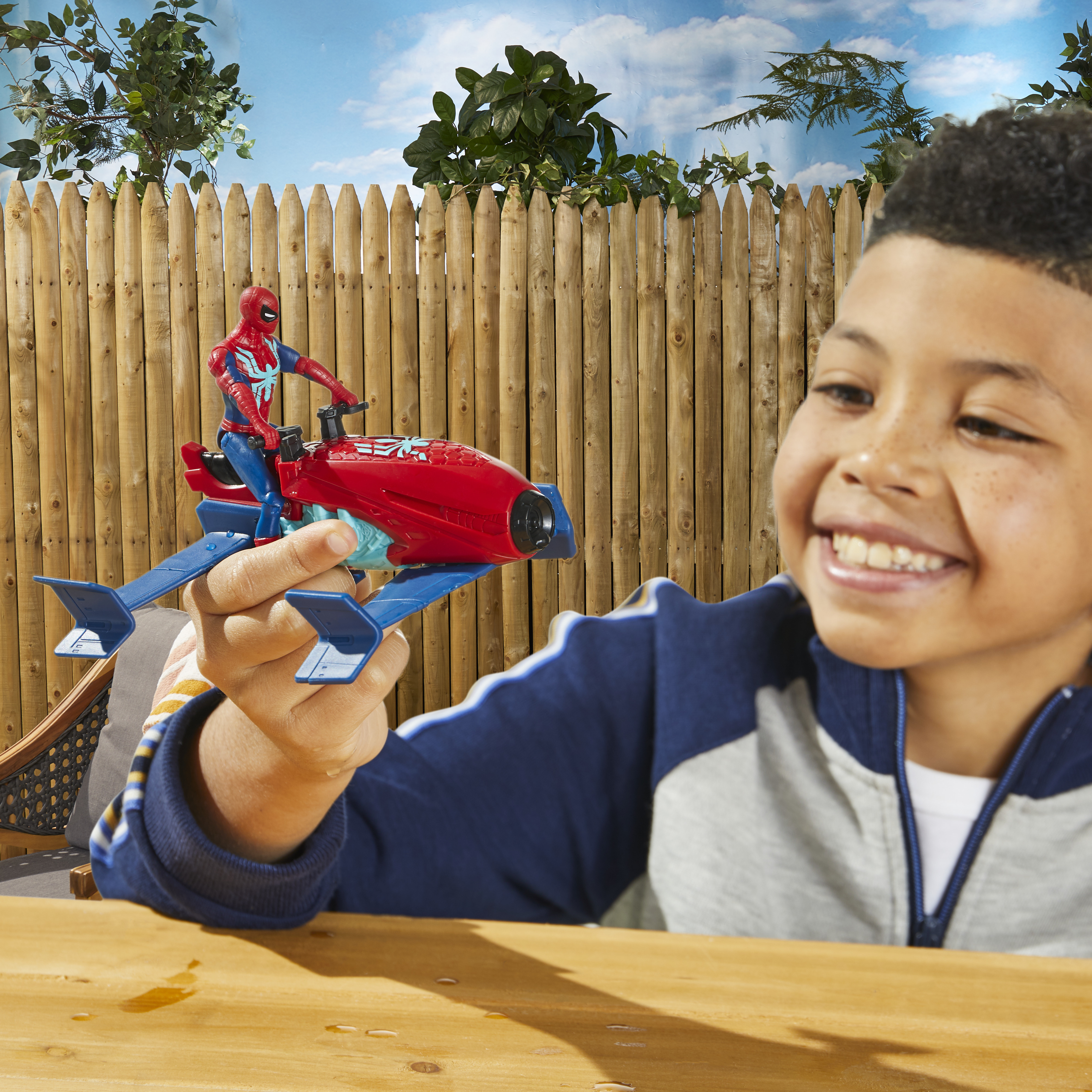Ragazzo che tiene una moto giocattolo di Spider-Man con sfondo.