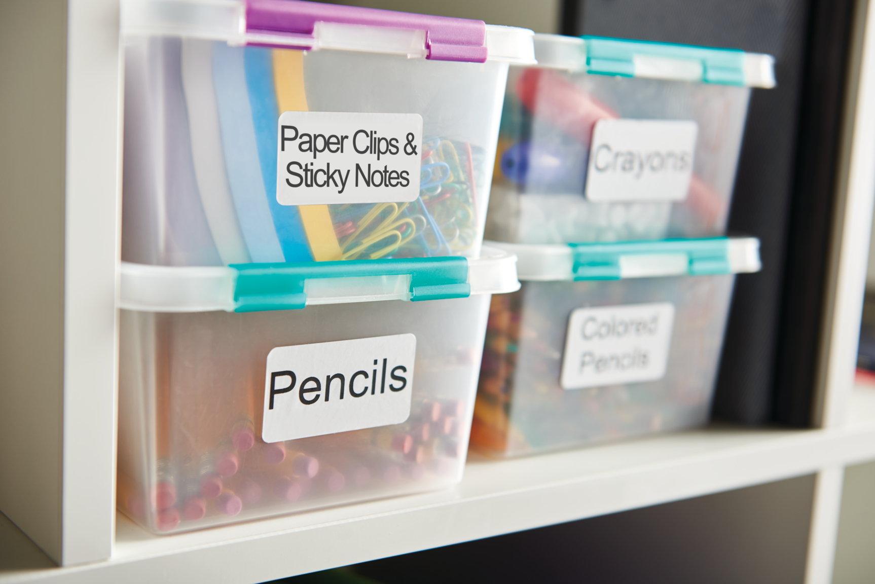 Transparente Kunststoff-Aufbewahrungsbehälter mit den Aufschriften 'Paper Clips & Sticky Notes', 'Pencils', 'Crayons'.