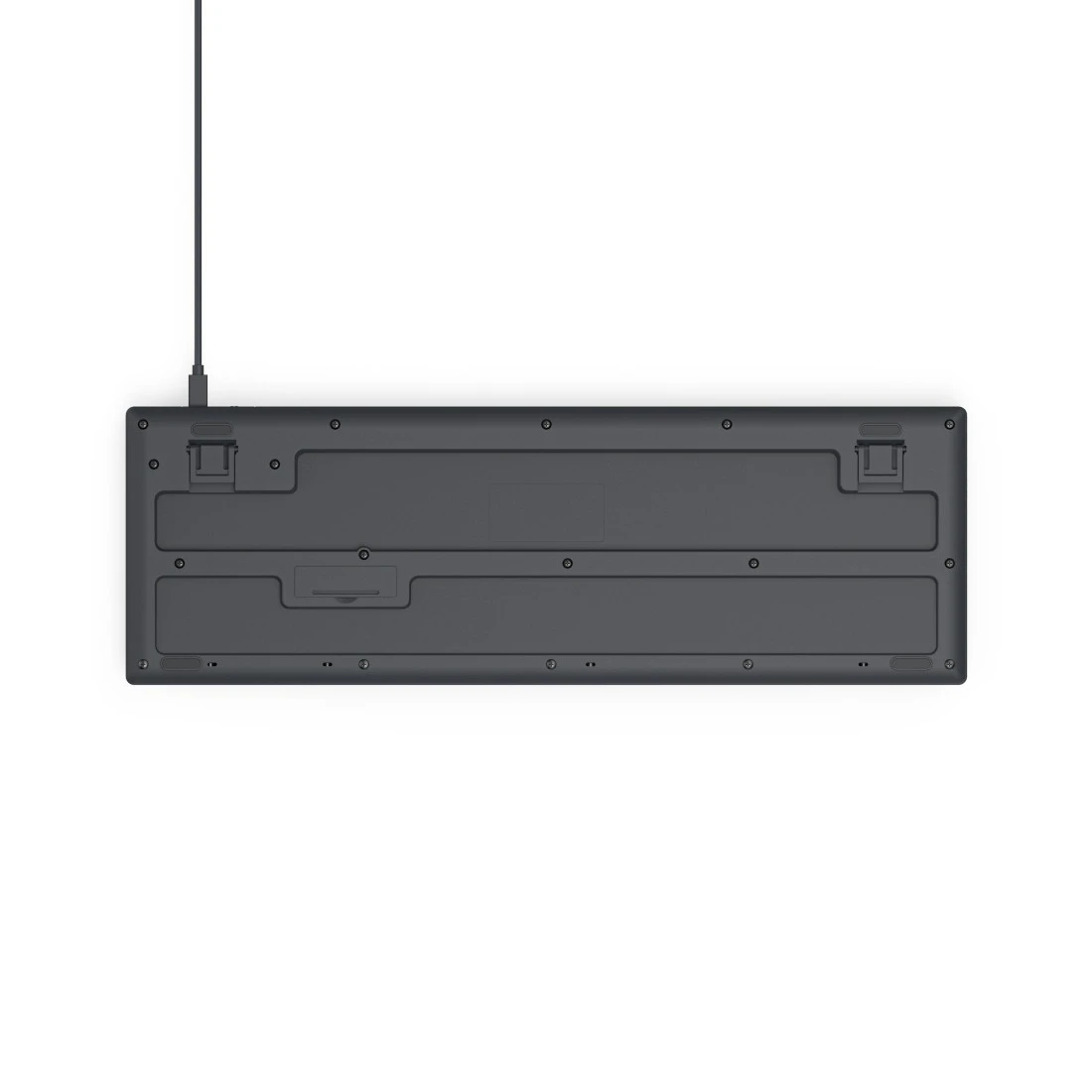 Widok od spodu szarej klawiatury z kablem. Widoczne są liczne śruby.