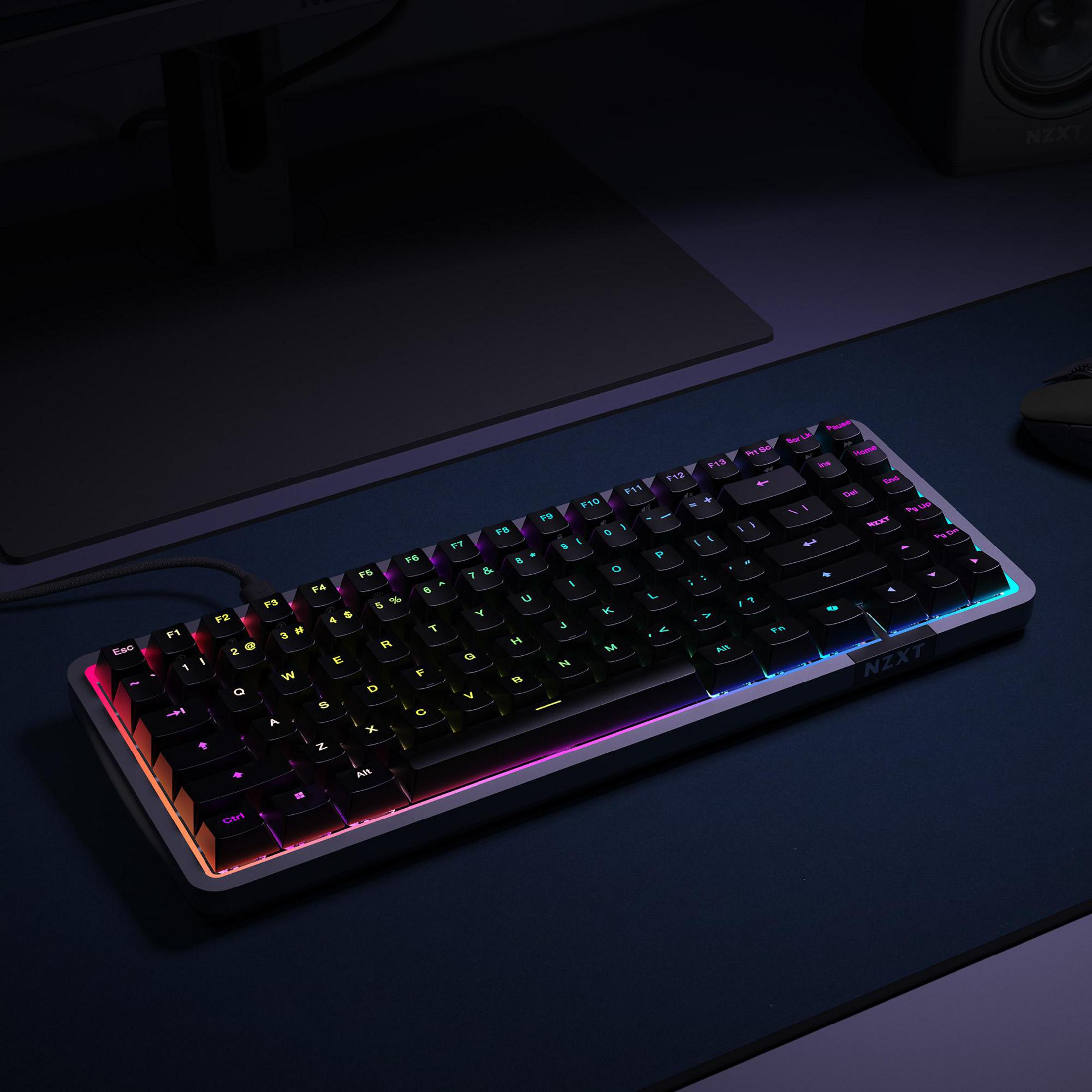 Eine schwarz-graue Tastatur mit bunter Beleuchtung auf einem Schreibtisch. Mit NZXT Logo.