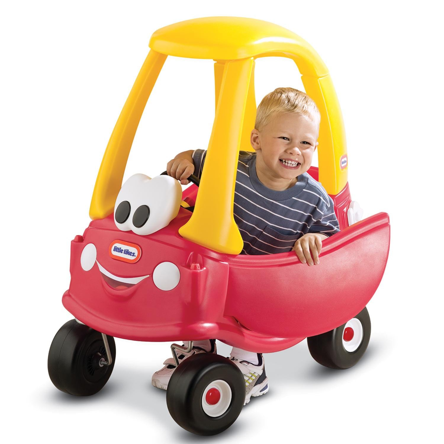 Ein Kind sitzt in einem roten Little Tikes Cozy Coupe Auto. Lächelt, gelbes Dach, schwarze Räder.