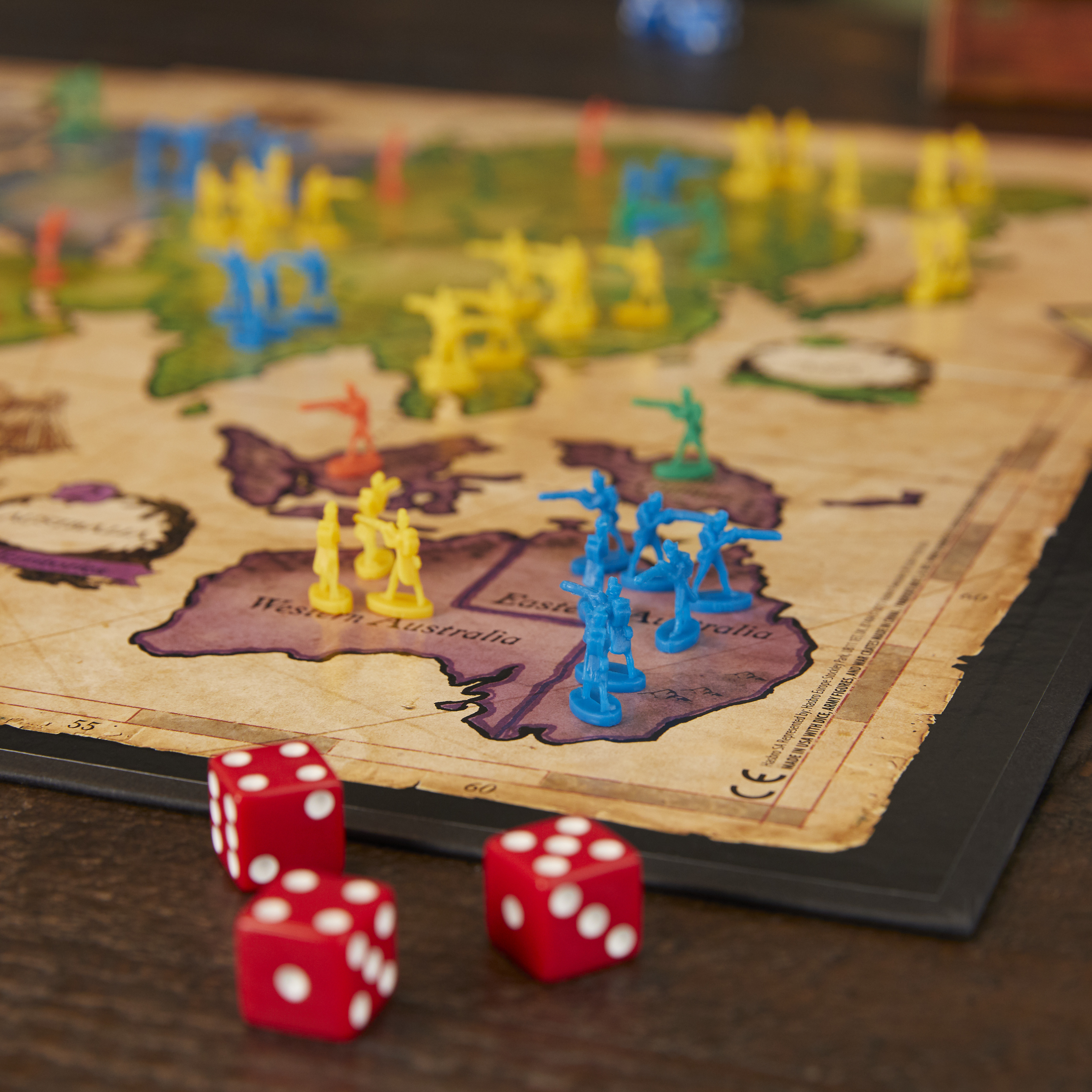 Primo piano di un gioco da tavolo con soldatini su una mappa. Dadi rossi.