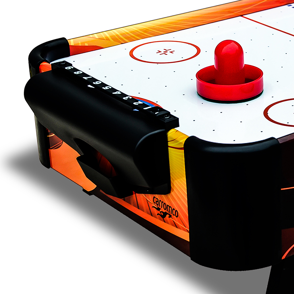 Dettaglio tavolo air hockey, disco rosso, tabellone nero, design arancione.