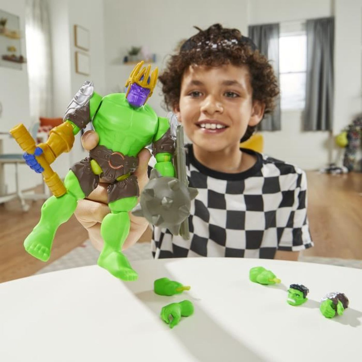 Niño sosteniendo un robot de juguete verde con accesorios. Un niño sonríe detrás.