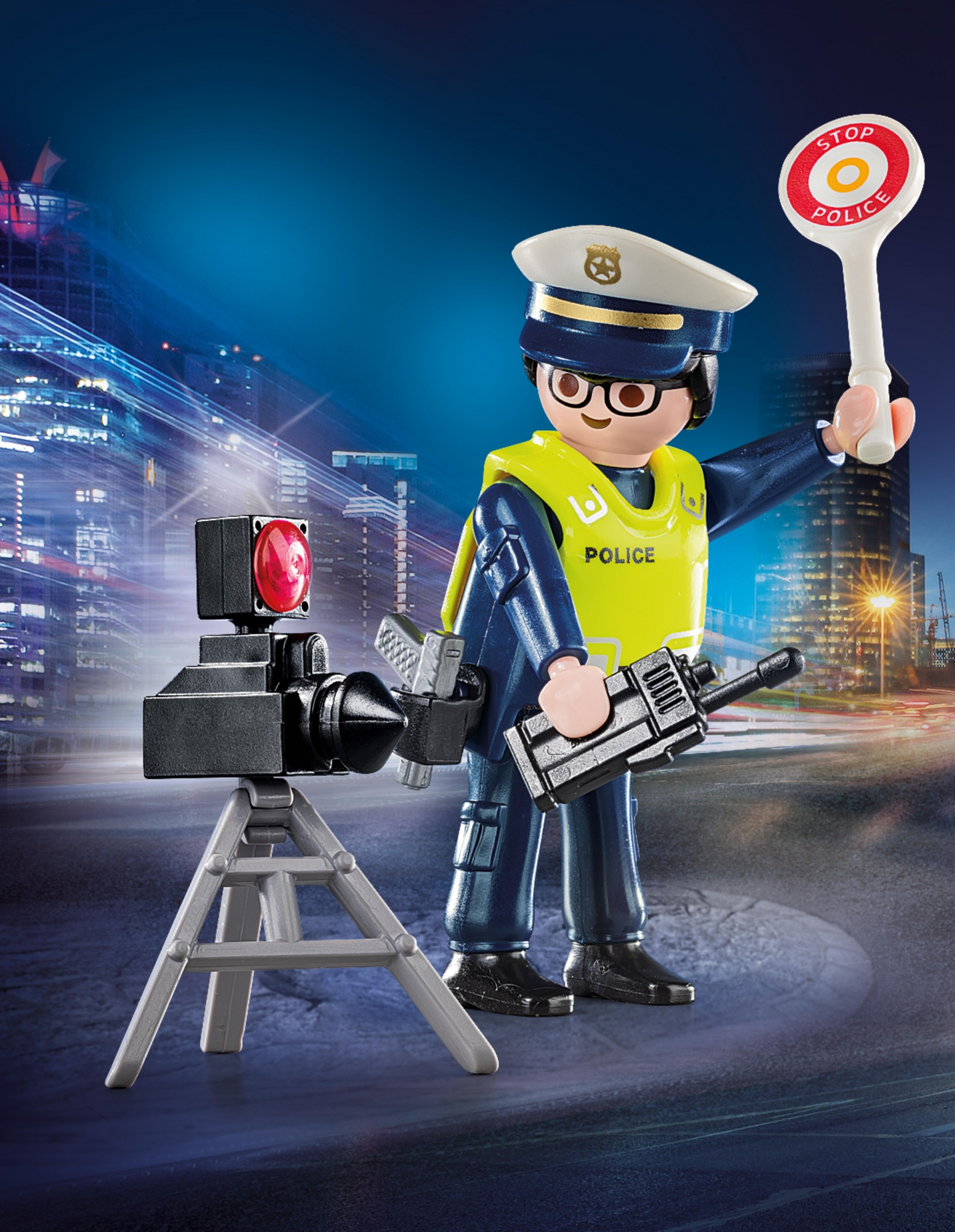 Policjant Playmobil z znakiem stop i radiem, z fotoradarem. Tło miasta.