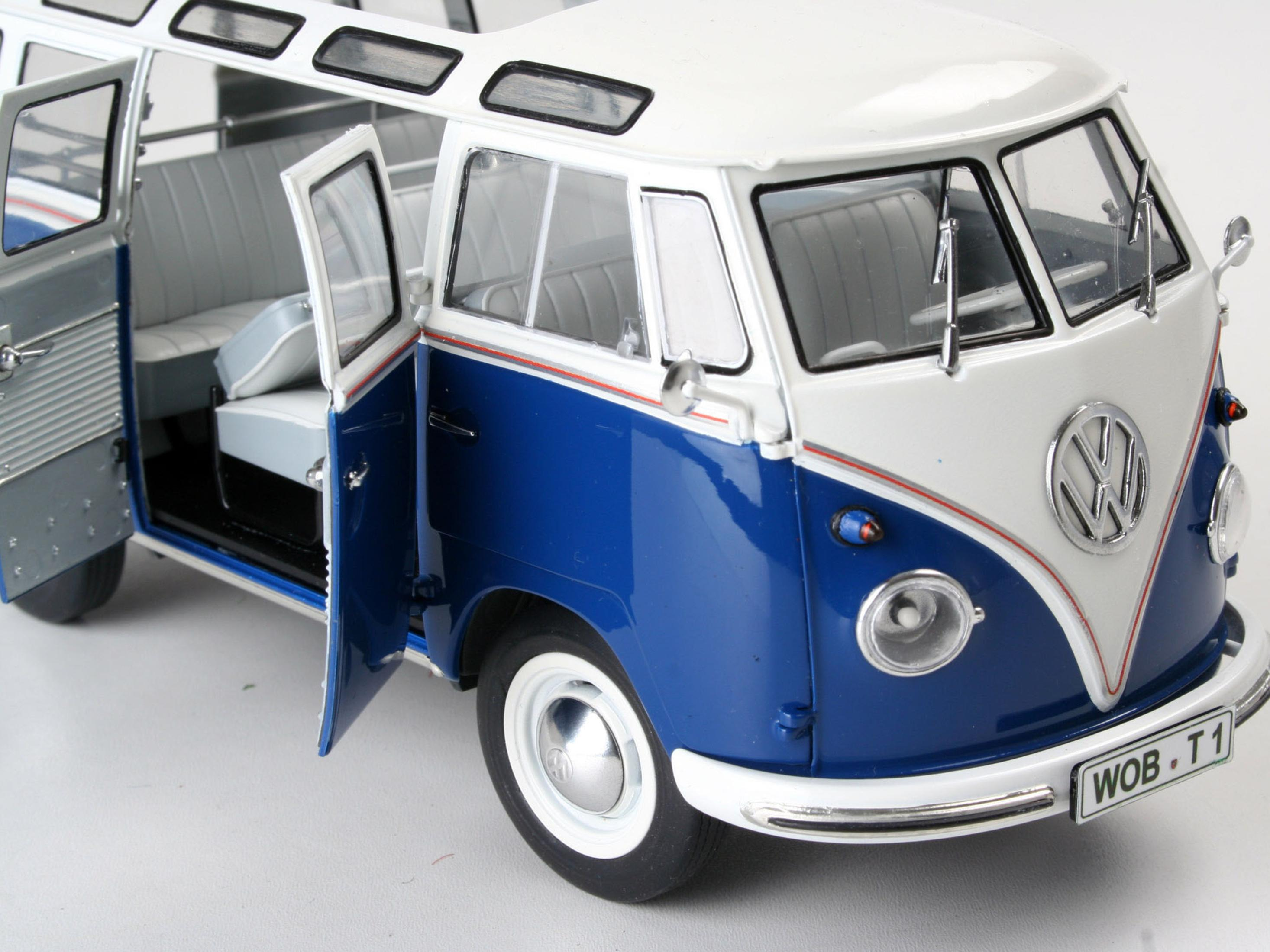 Primo piano di un modello di autobus Volkswagen T1 Samba blu e bianco con le porte aperte, che rivela i dettagli interni.