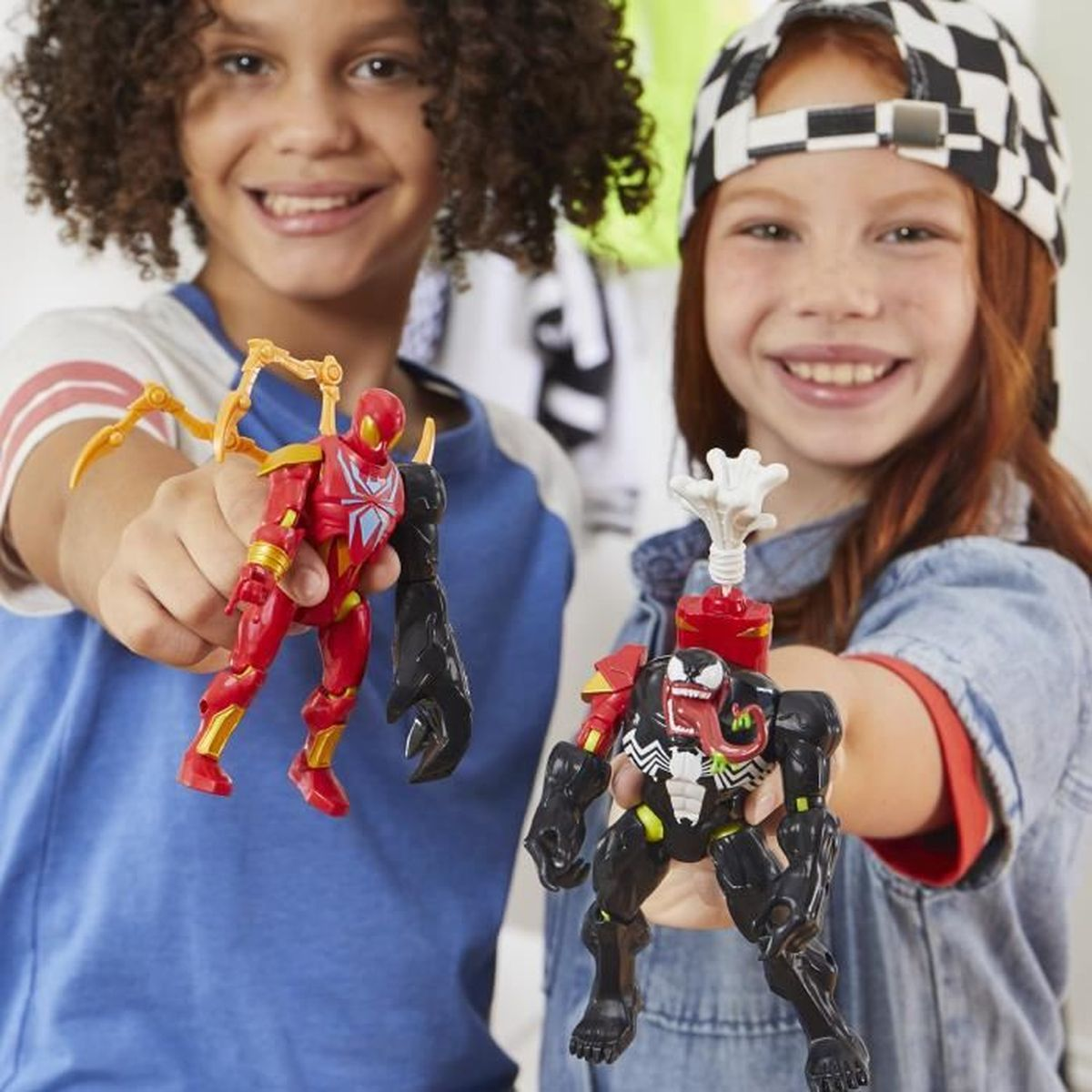 Dos niños sosteniendo juguetes Marvel Mix Mashers, un Iron Man rojo y una figura de Venom negra.
