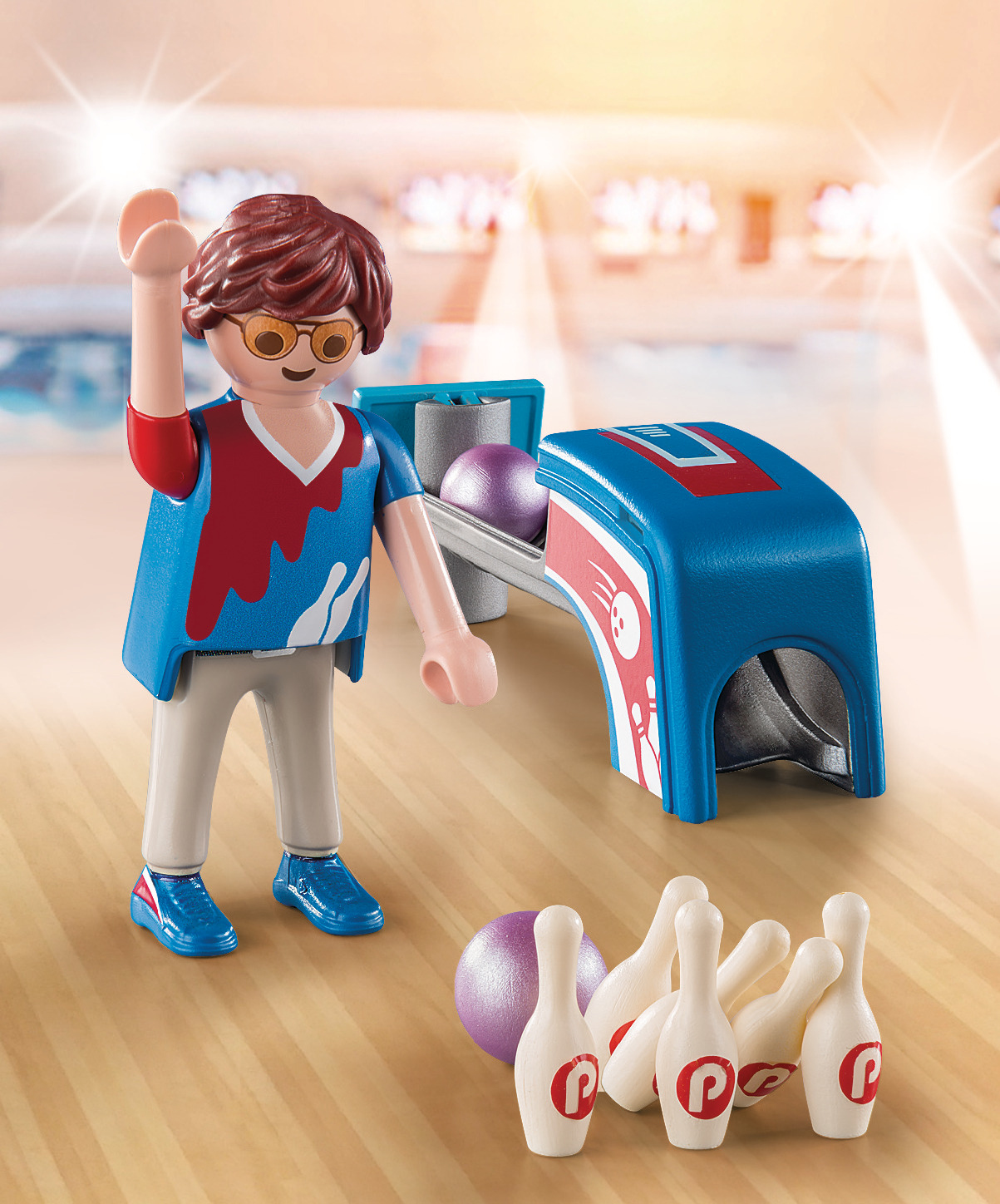 Scena gry w kręgle Playmobil z postacią, która ma rzucić, kręglami, kulą do kręgli i maszyną, na drewnianej podłodze.