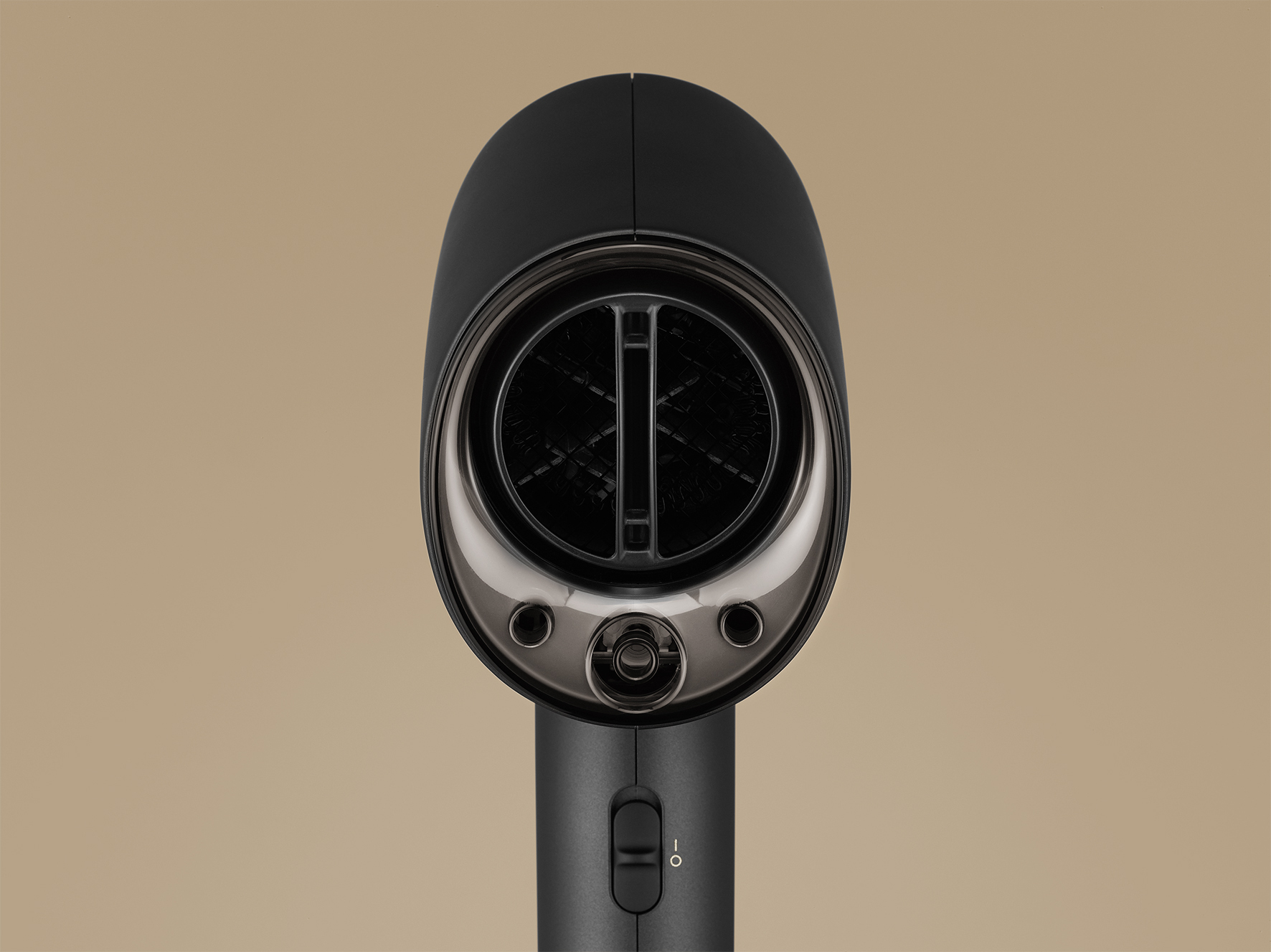 Zbliżenie przodu czarnej suszarki do włosów, pokazujące wlot powietrza i elementy sterujące.