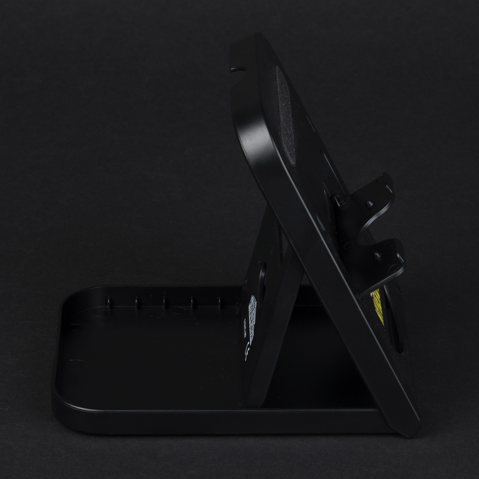 Czarny stojak na telefon z widokiem z boku. Ciemne tło.