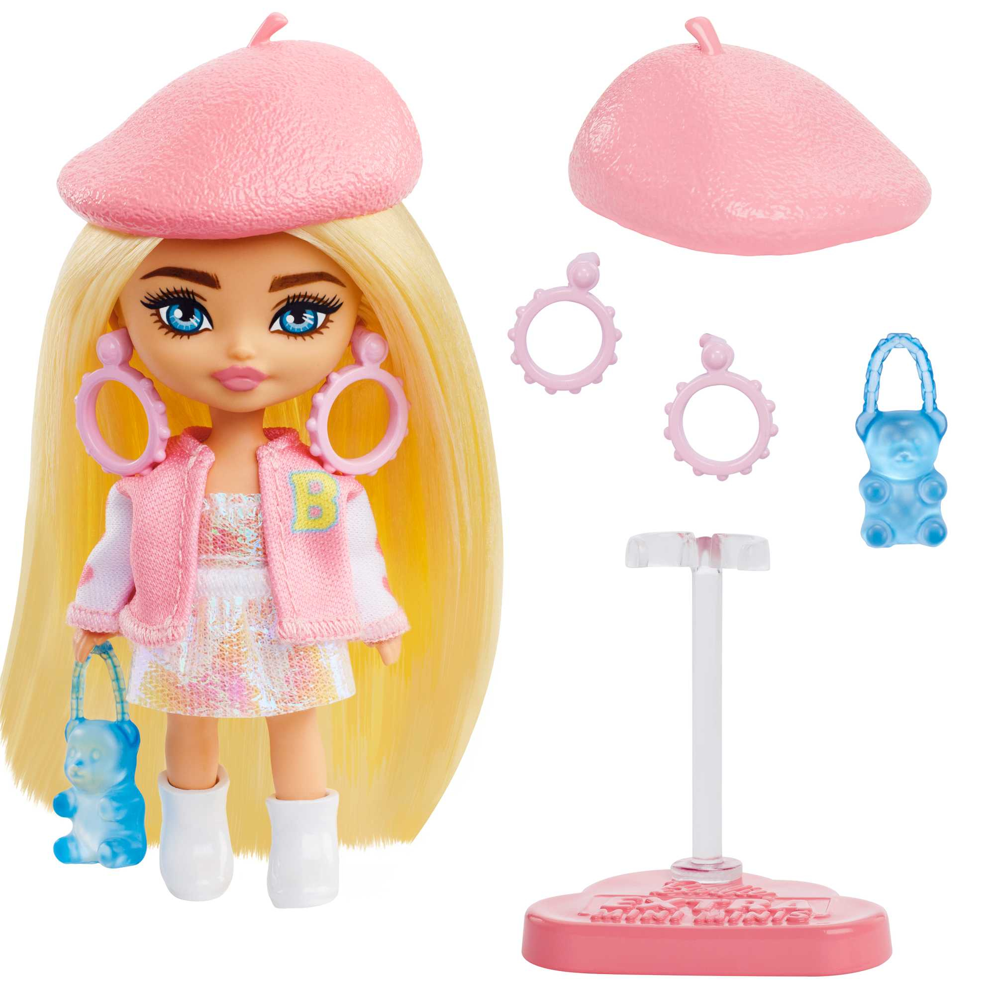 Eine Puppe mit blonden Haaren, rosa Barett und Ohrringen. Sie trägt eine weiße Jacke, eine blaue Geldbörse und weiße Stiefel. Zubehör.