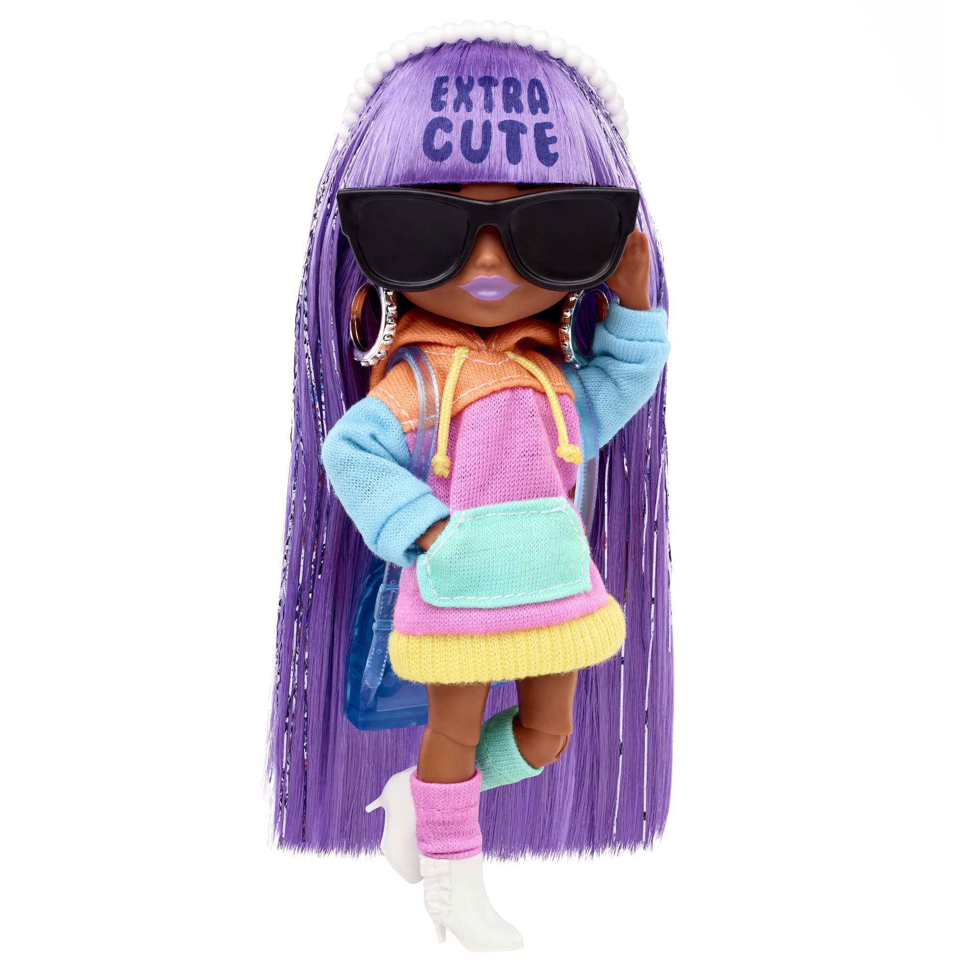 Eine Puppe mit lila Haaren, Sonnenbrille und Kapuzenpullover. Die Puppe trägt weiße Schuhe.