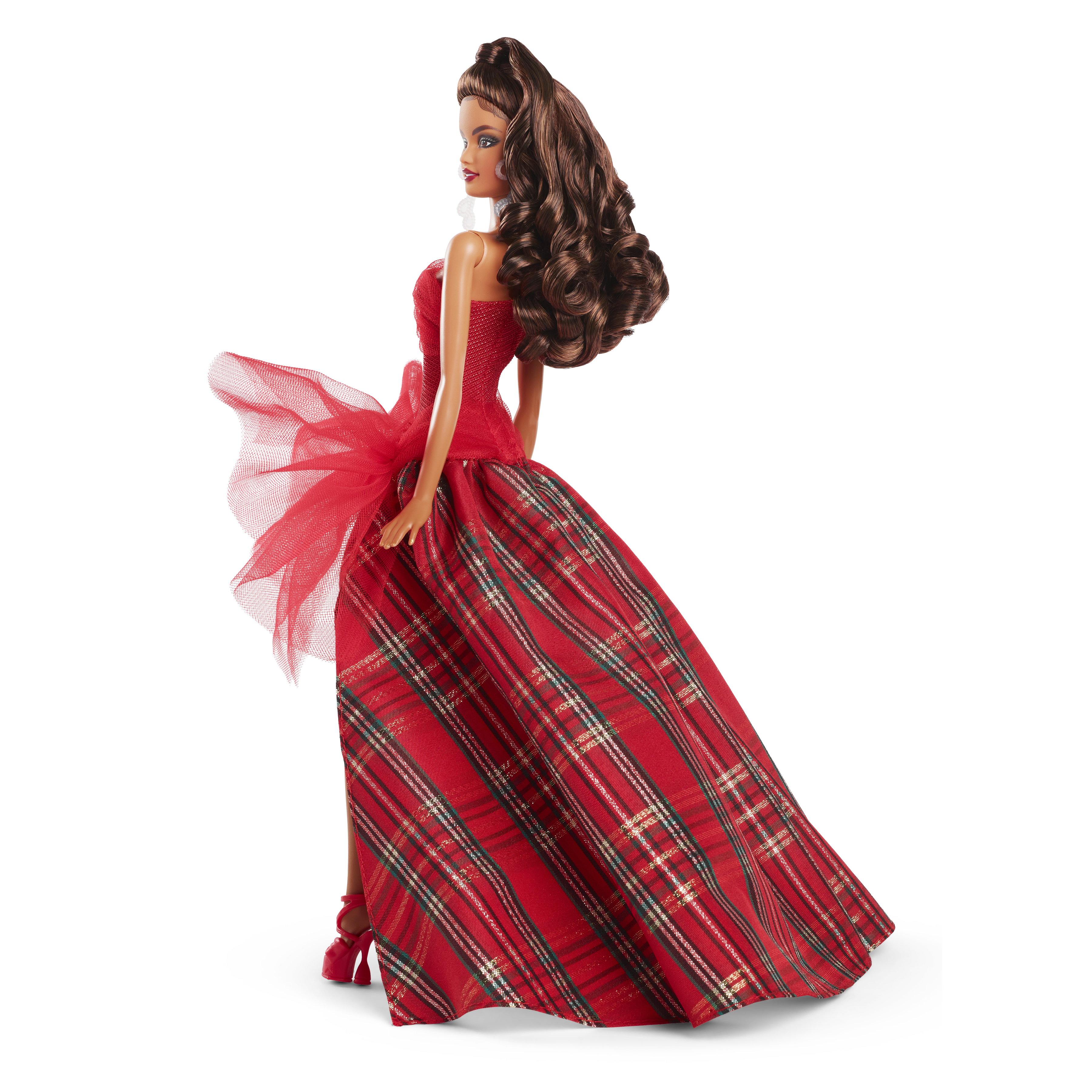 Eine Barbie-Puppe in einem roten Kleid mit kariertem Rock und roter Schleife, posierend.