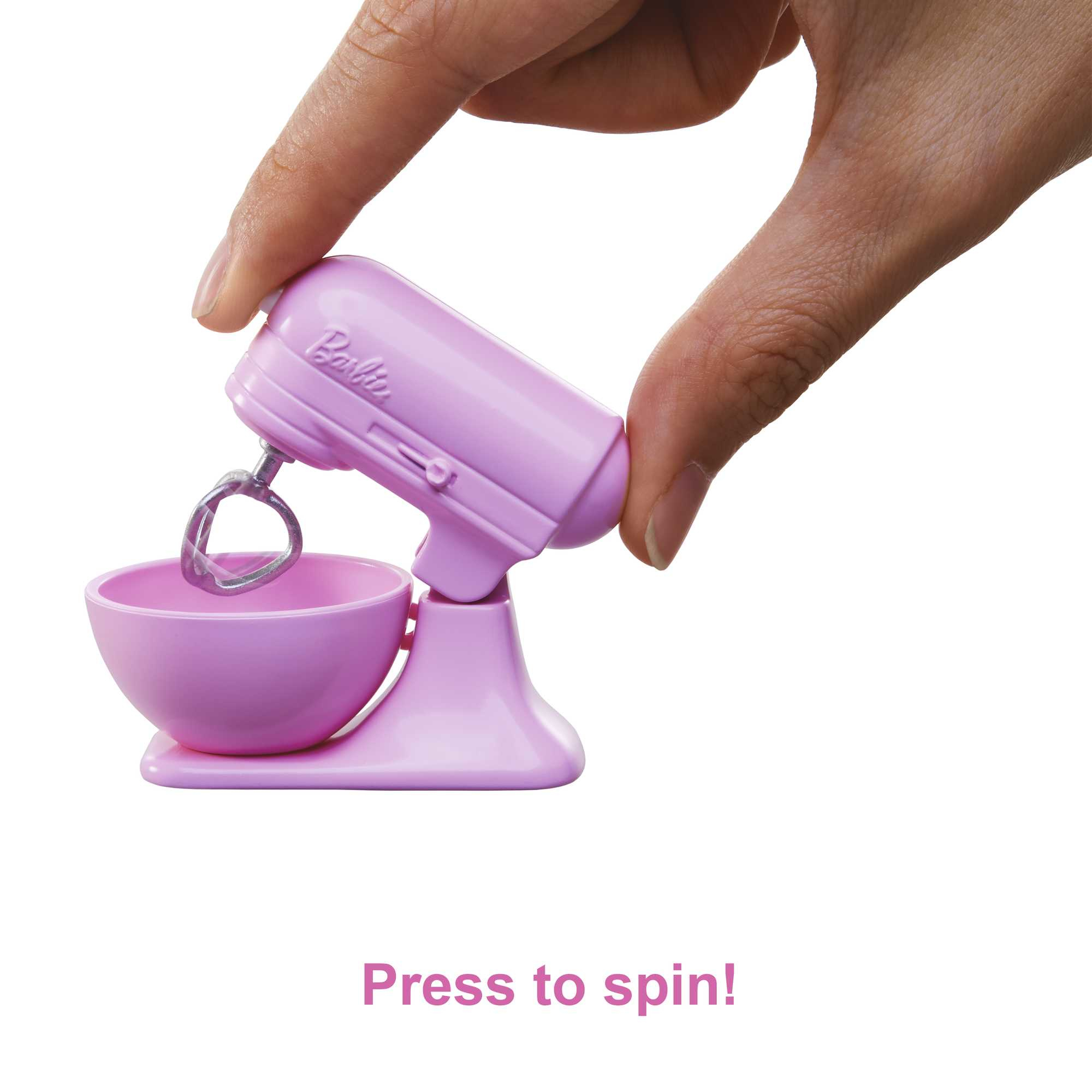 Una mano sosteniendo una batidora de juguete rosa en miniatura con un cuenco, con el texto '¡Pulsa para girar!' debajo.