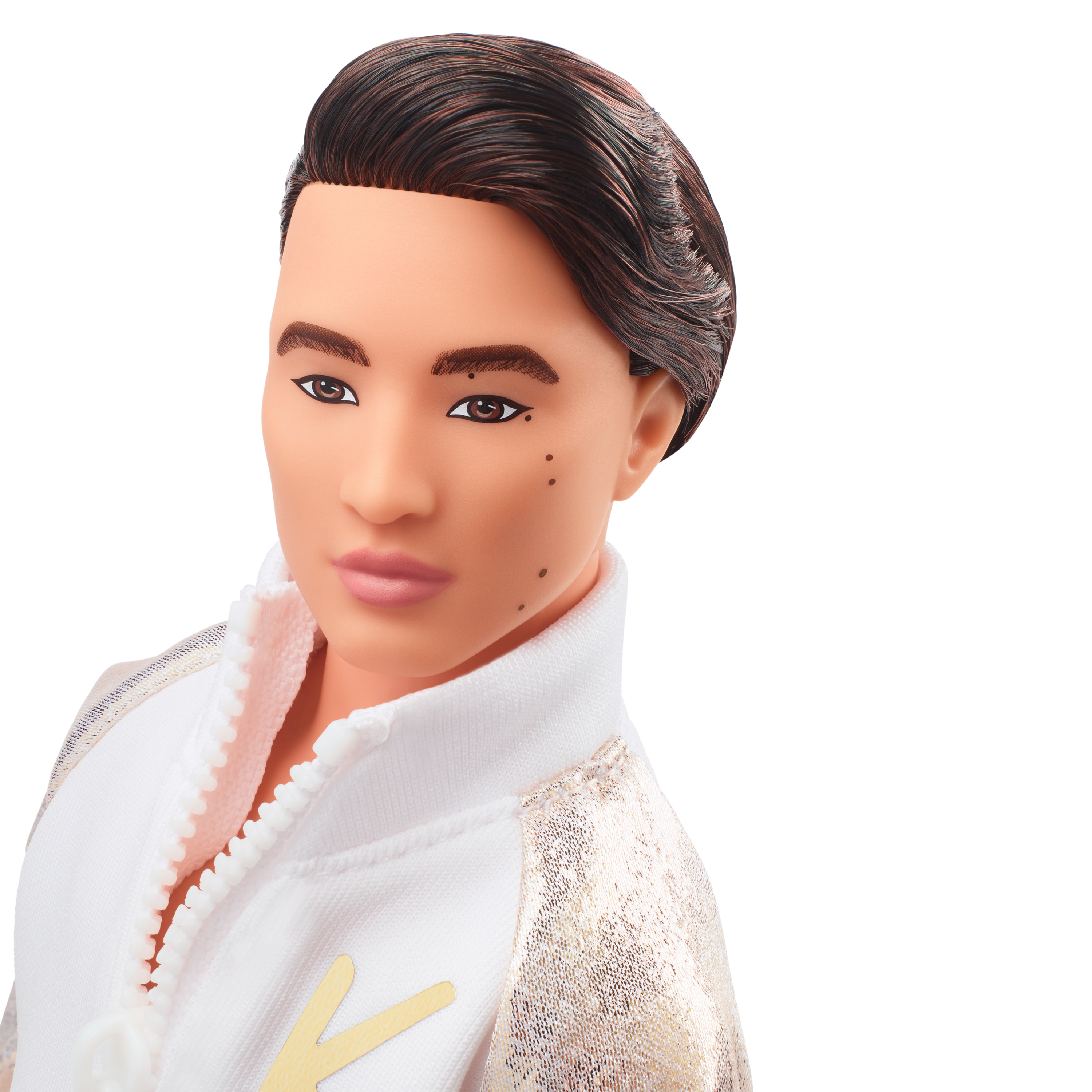 Nahaufnahme des Gesichts einer Ken-Puppe. Er hat dunkles Haar, eine weiße Jacke mit goldenen Akzenten und einen neutralen Ausdruck.
