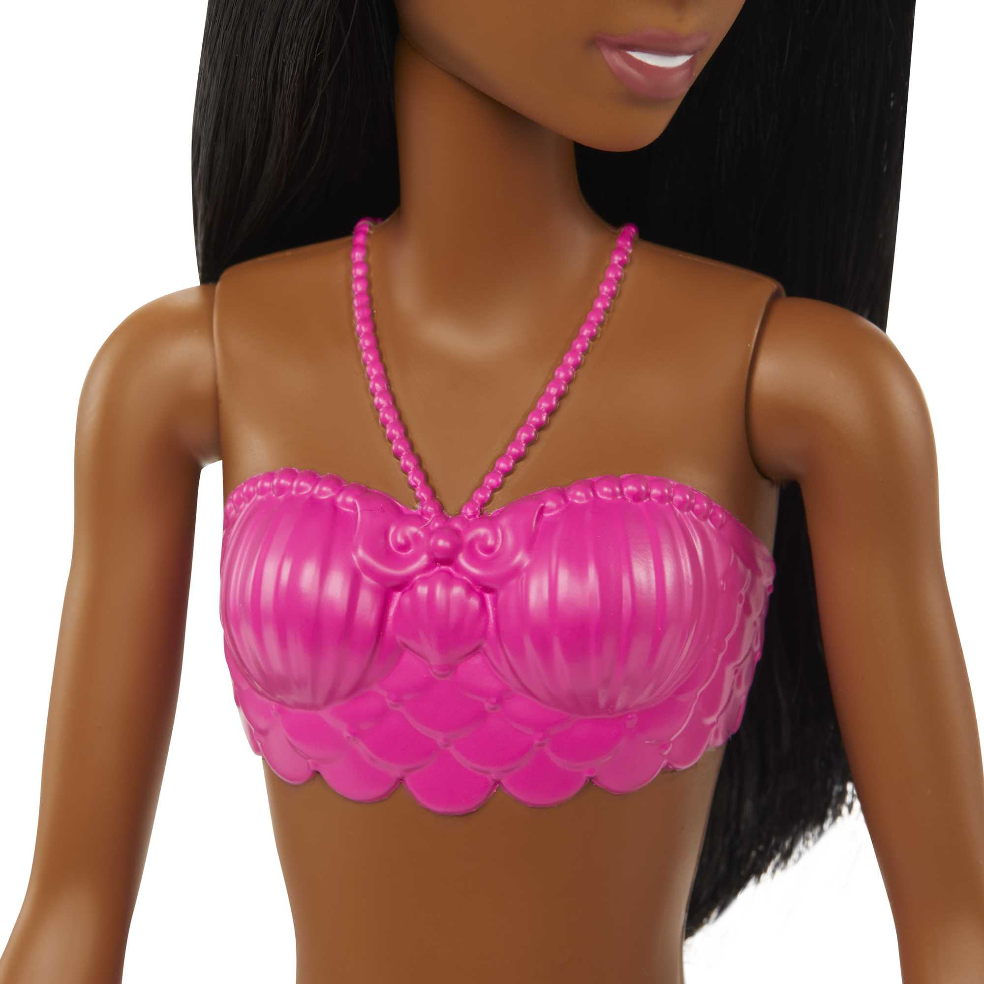 Nahaufnahme des Oberkörpers einer Barbie-Meerjungfrauenpuppe mit pinkfarbenem Muscheloberteil und dunklem Hautton.
