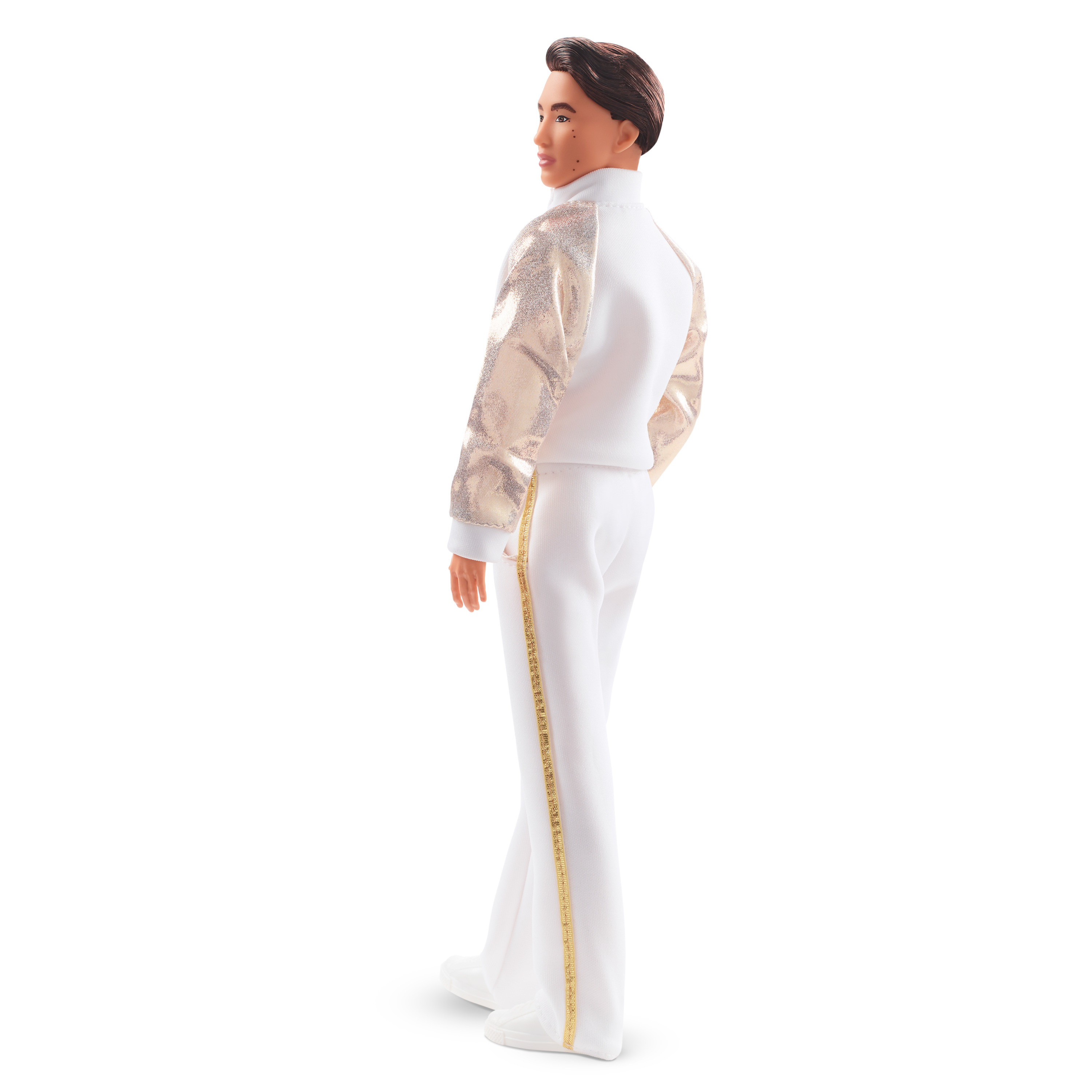 Eine Ken-Puppe in einem weißen und goldenen Outfit, die dem Betrachter den Rücken zukehrt, mit weißem Hintergrund.