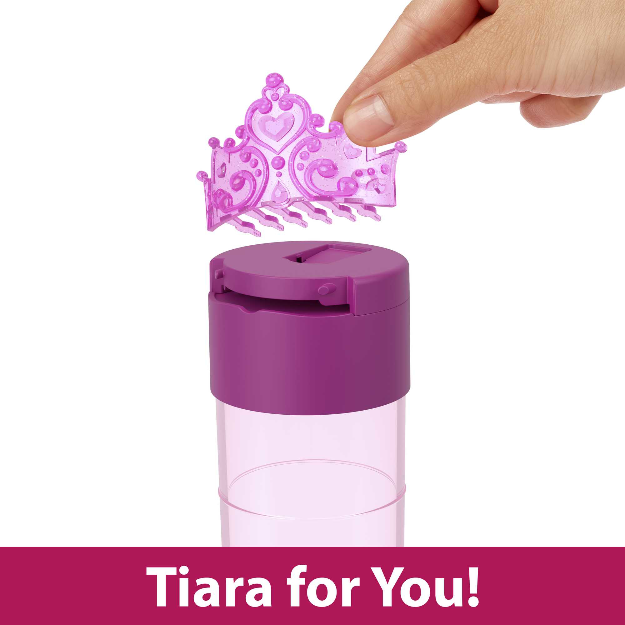 Dłoń umieszczająca fioletową tiarę na fioletowym pojemniku.