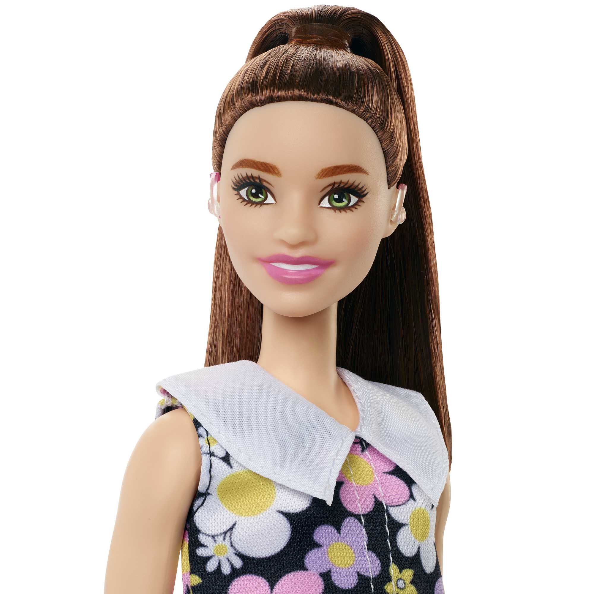 Barbie-Puppe mit braunen Haaren im hohen Pferdeschwanz, trägt ein Blumenkleid.