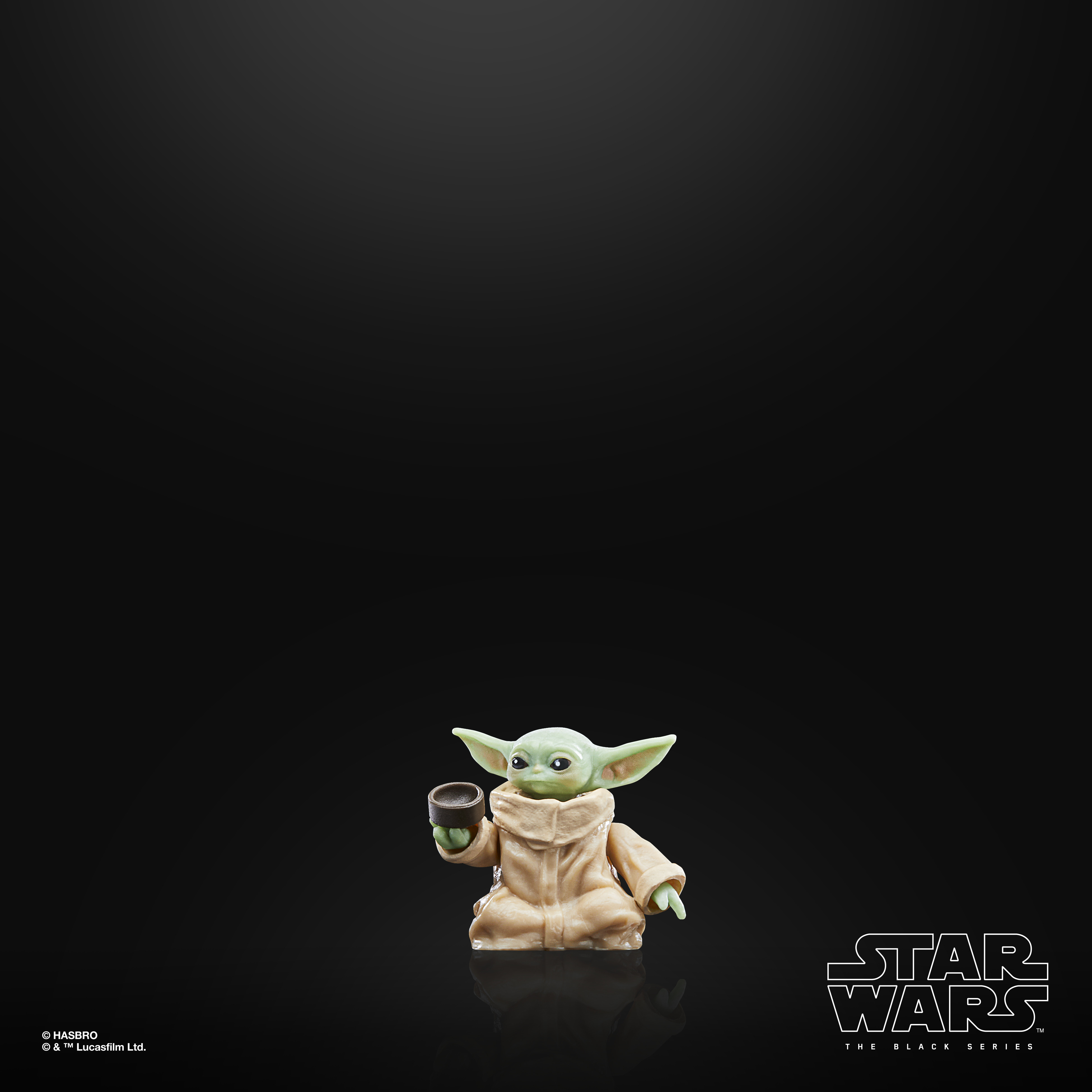 Baby Yoda con una tazza. Pelle verde, tunica beige e sfondo nero con logo Star Wars.