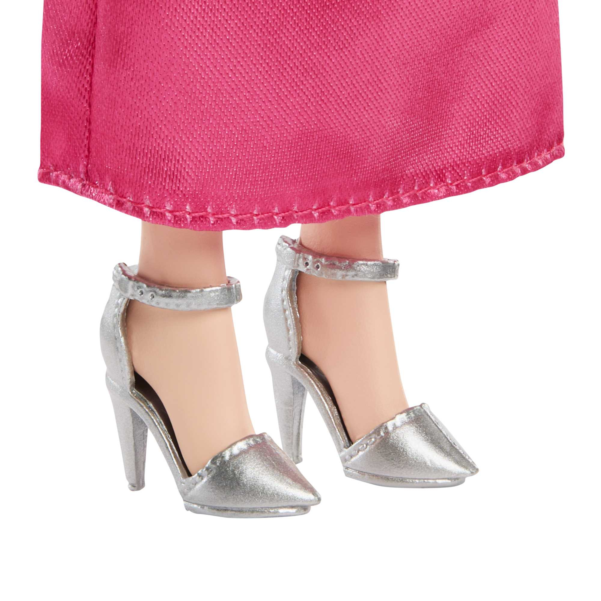 Nahaufnahme von silbernen High-Heels an einer Barbie-Puppe. Die Schuhe haben Knöchelriemen.