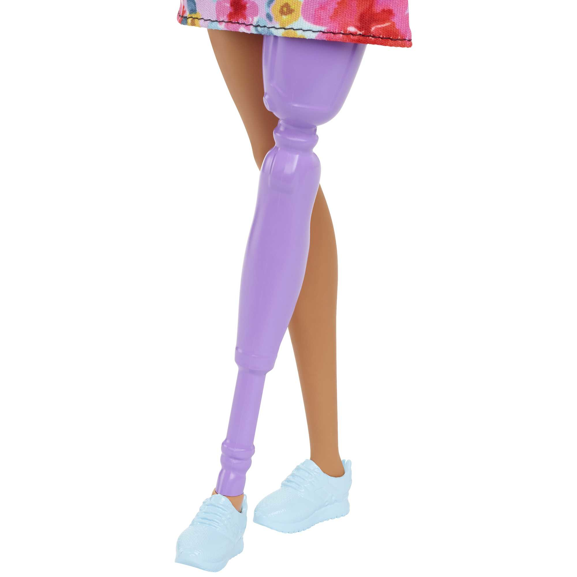 Barbies Beine mit einer Prothese. Sie trägt blaue Turnschuhe und einen geblümten Rock.