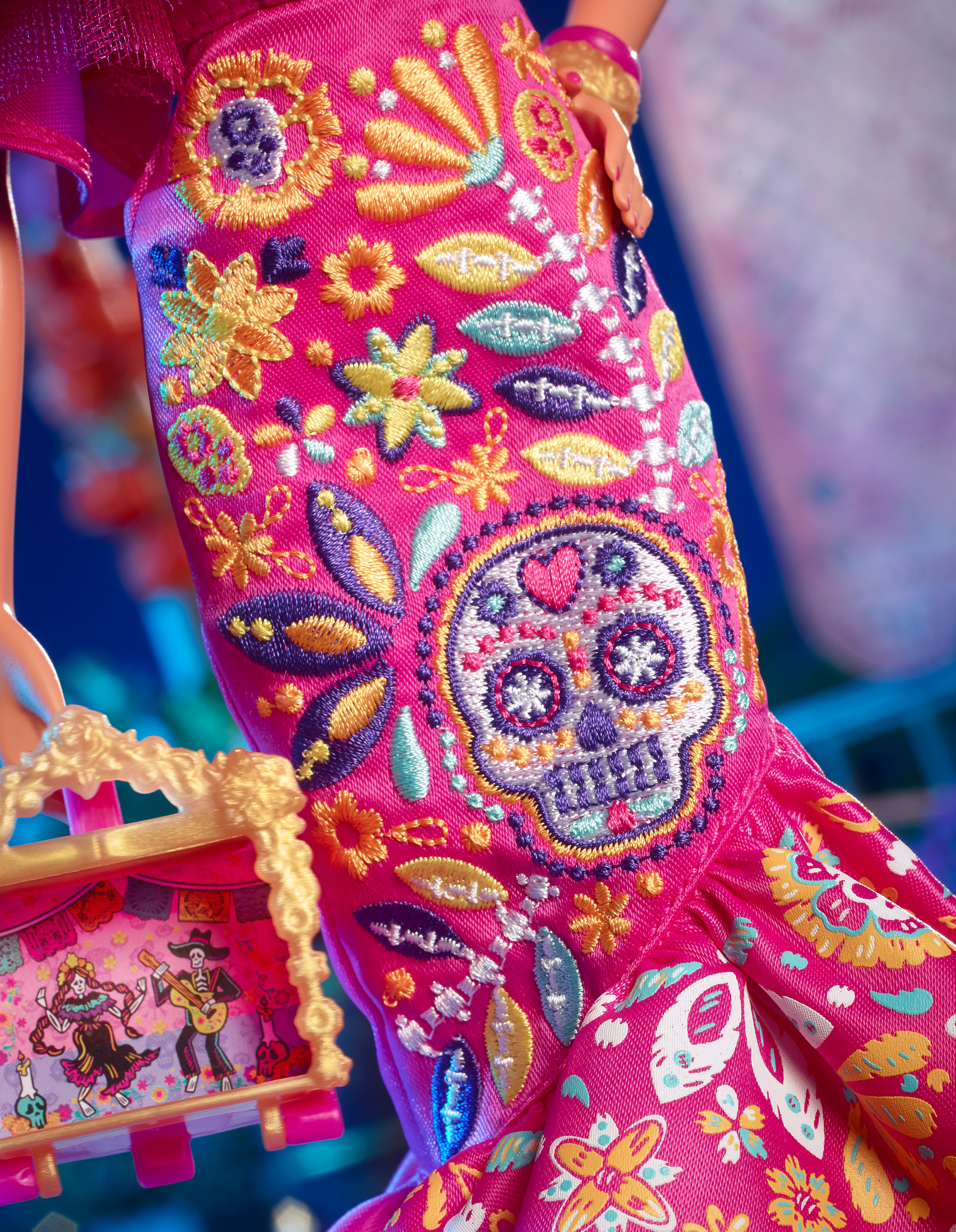 Barbie-Puppe in rosa Kleid mit Totenkopf-Stickerei, hält ein Gemälde.