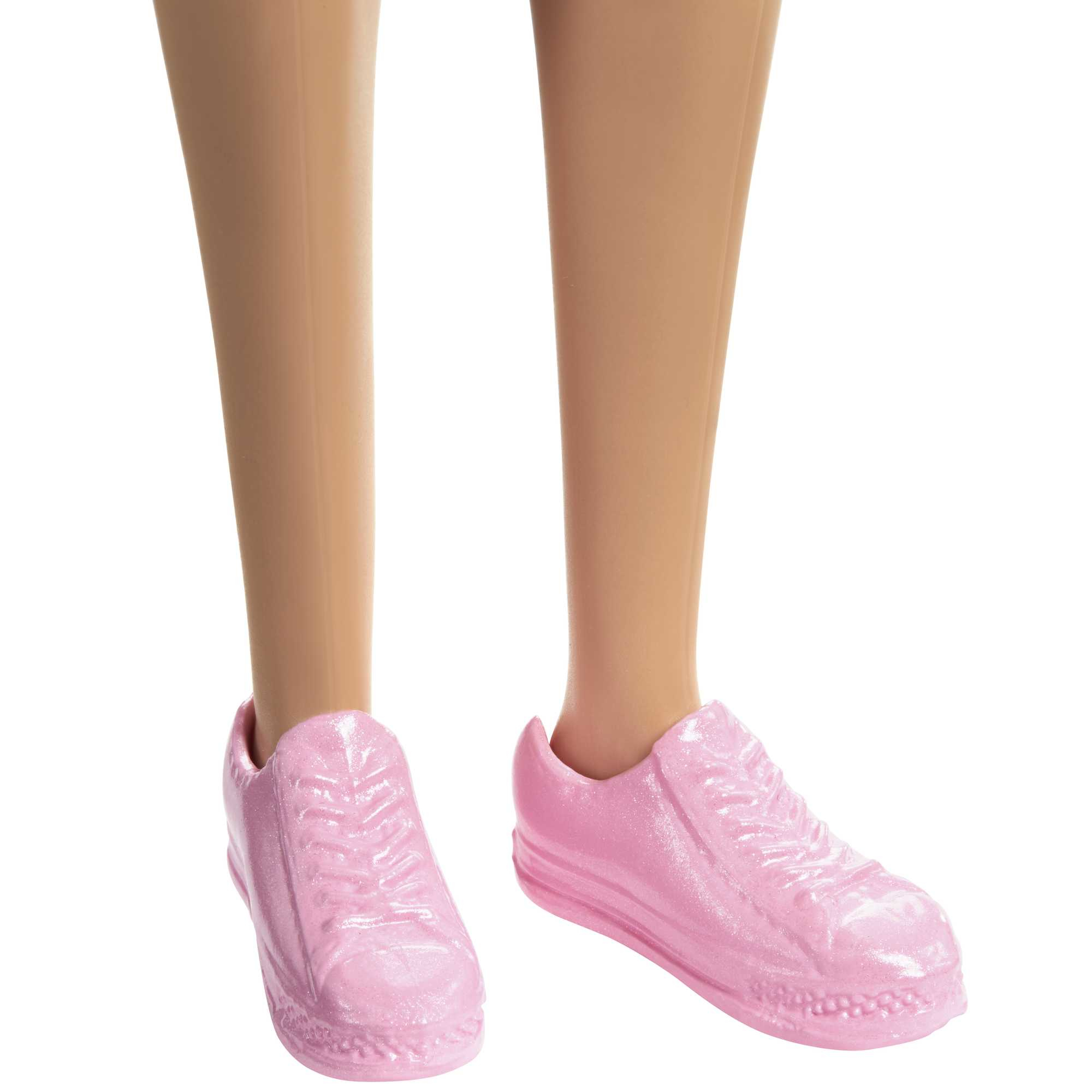Nahaufnahme von Puppenbeinen und -füßen in pinkfarbenen Turnschuhen. Die Beine sind hautfarben, die Schuhe glänzend rosa.