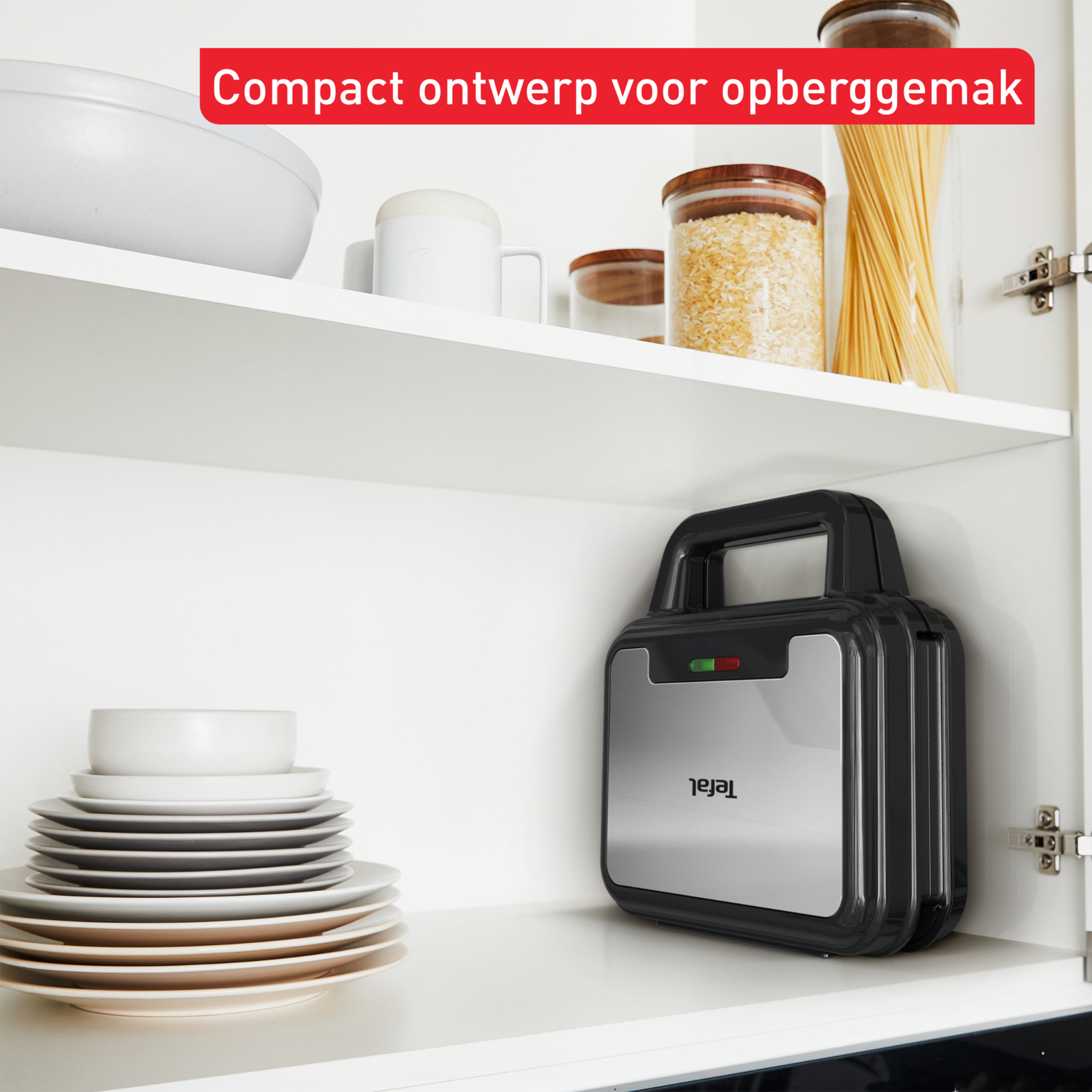 A black Tefal sandwich maker is stored in a white cabinet, with plates and other items.
